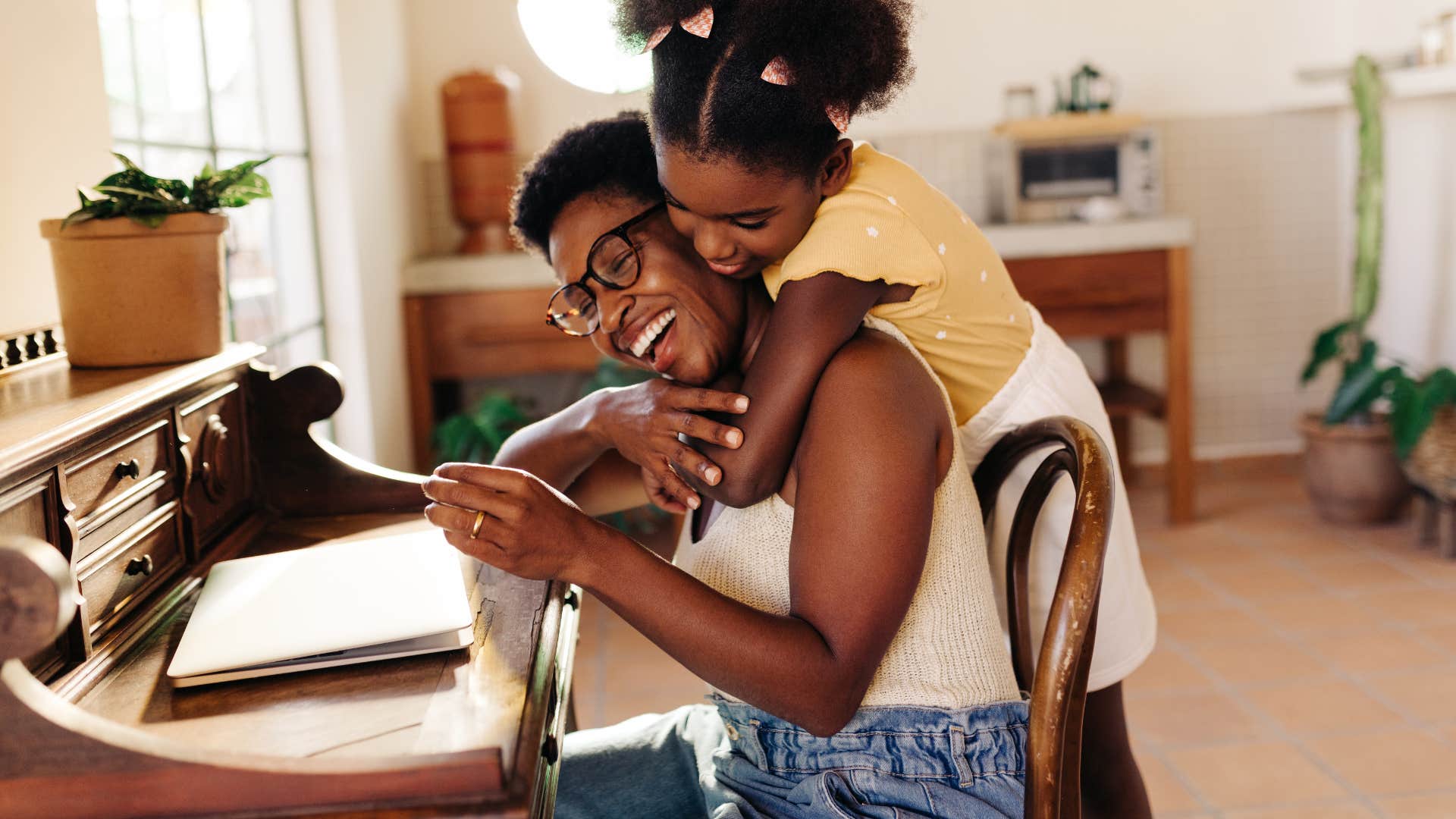 Young girl hugging her mom in their home