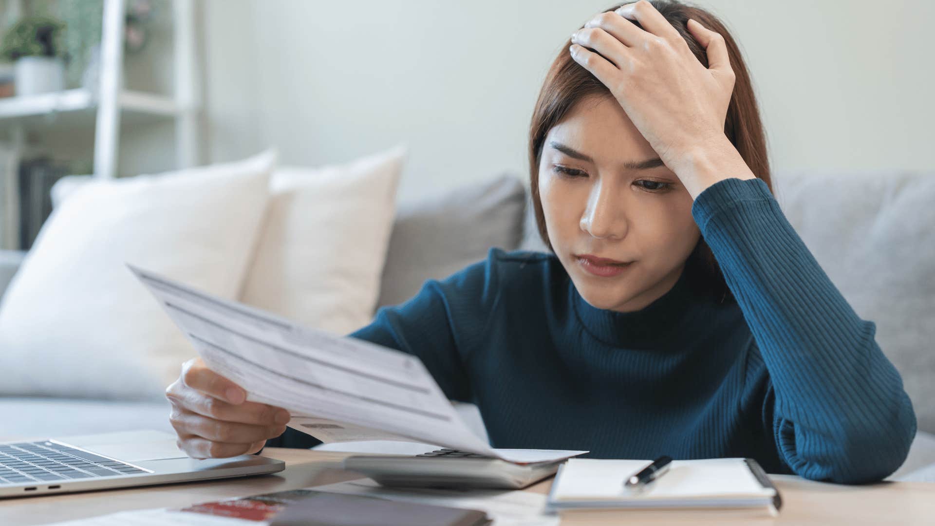 upset woman looking at bills