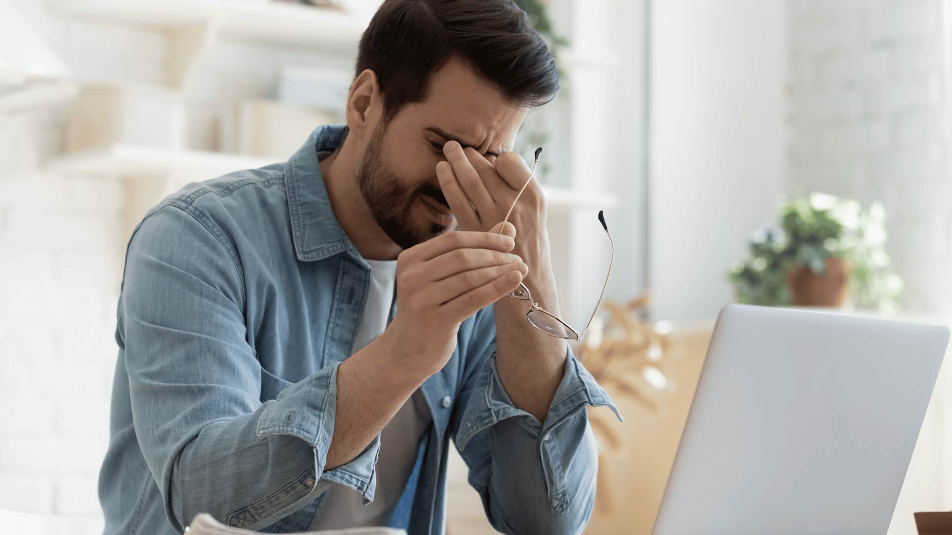 man rubbing his eyes