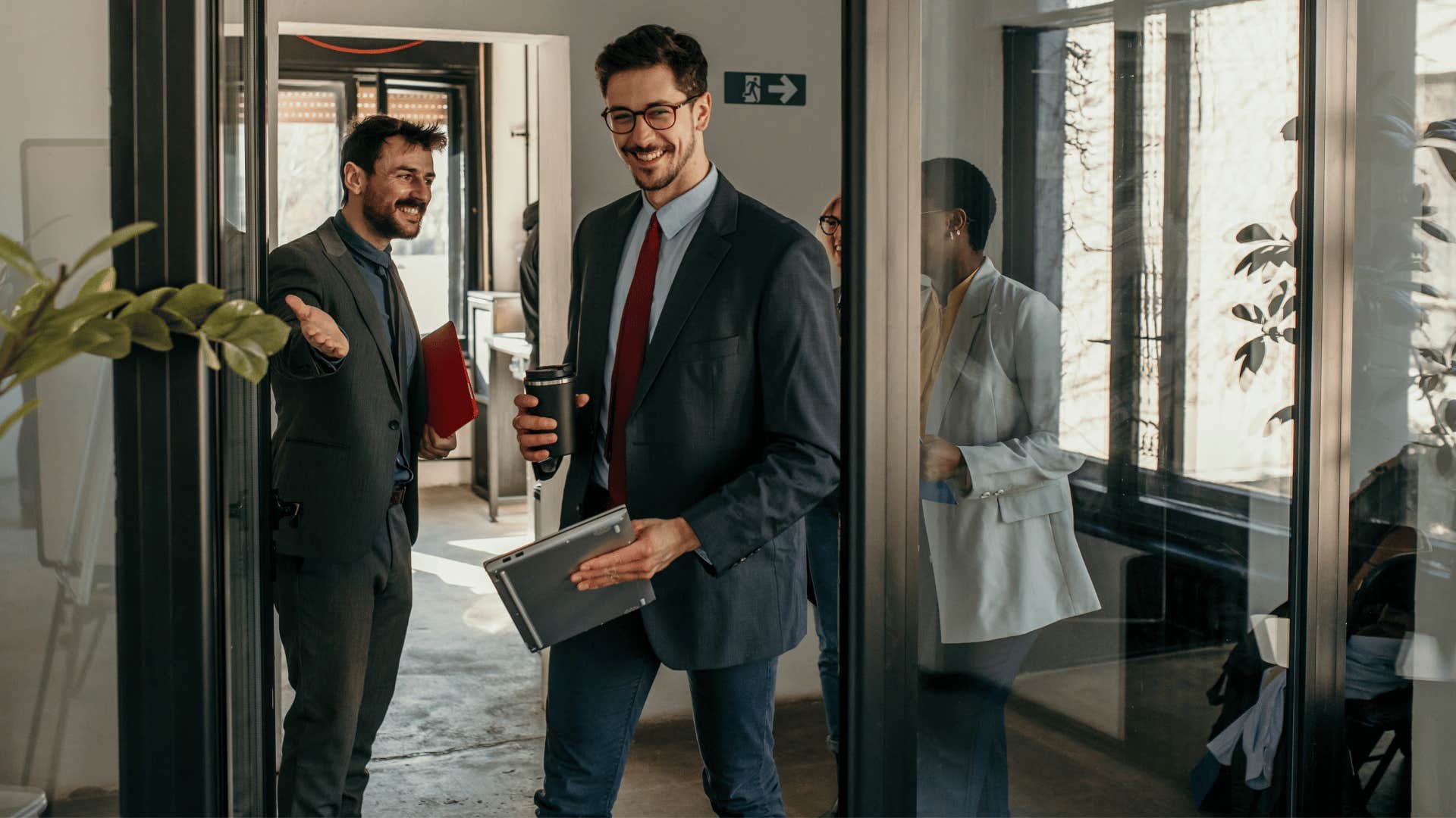 man walking through opened door holding space