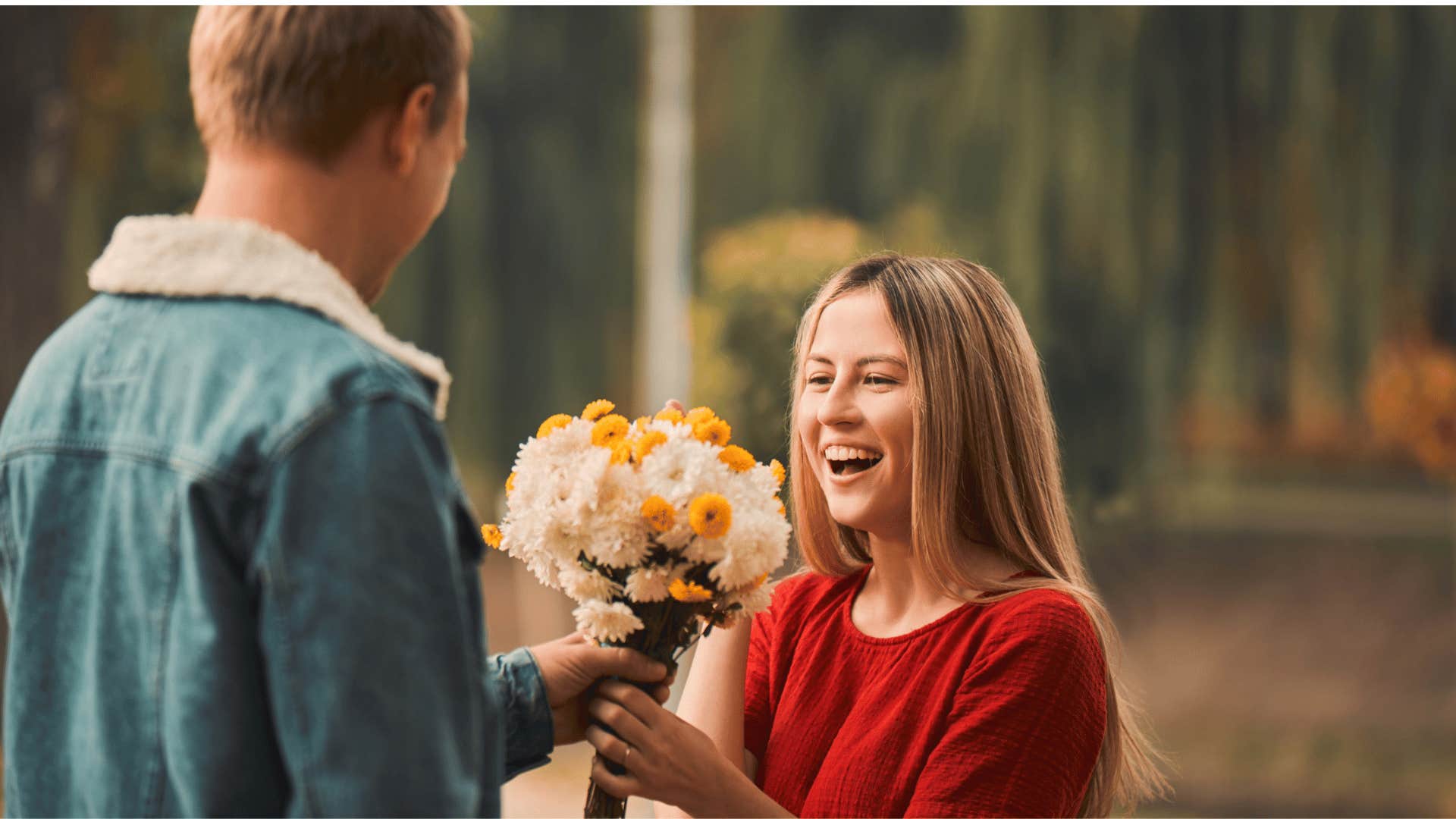 man surprising woman with flowers