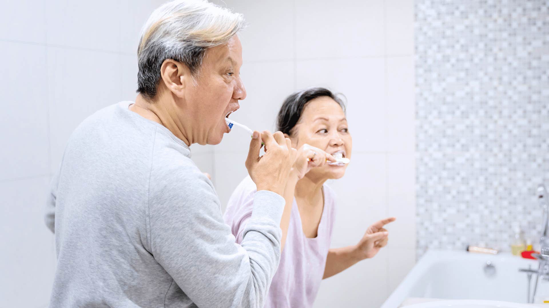 narcissistic man taking up unnecessary space in the bathroom with his wife