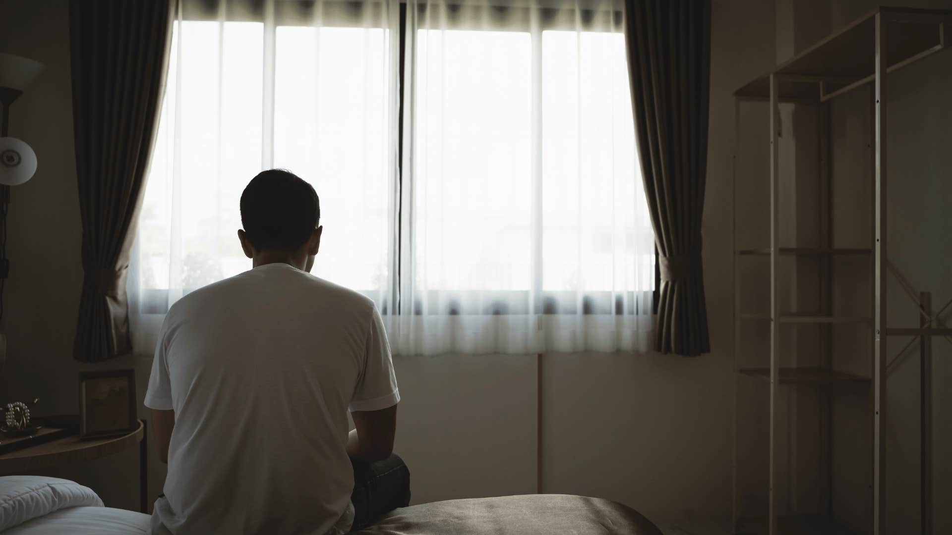 depressed man sitting on bed