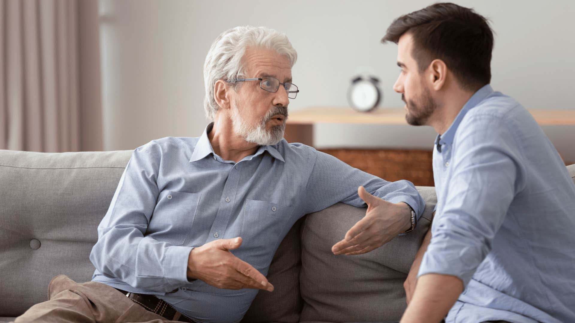 father and son talking on couch