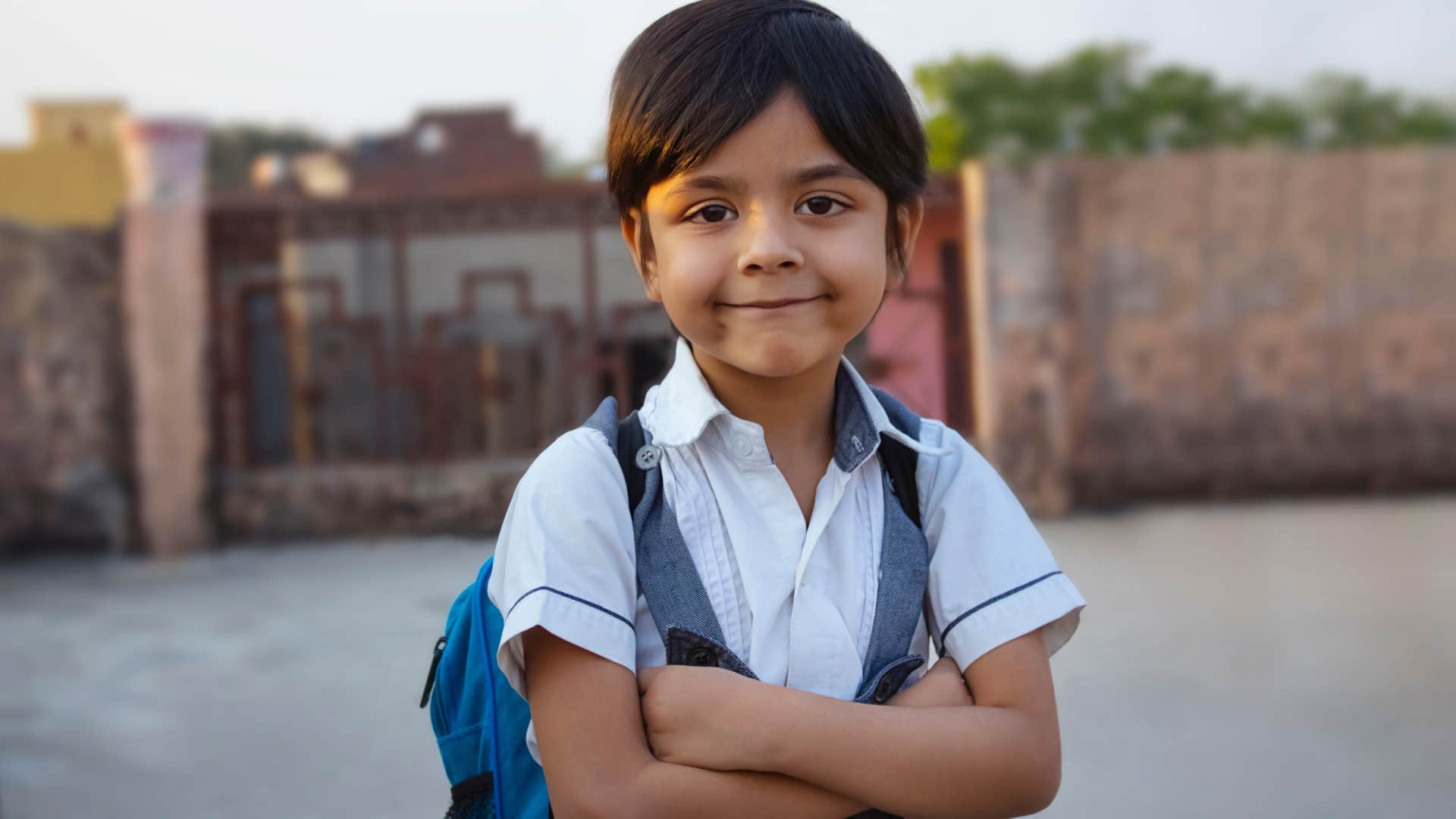 schoolgirl standing outside with arms crossed