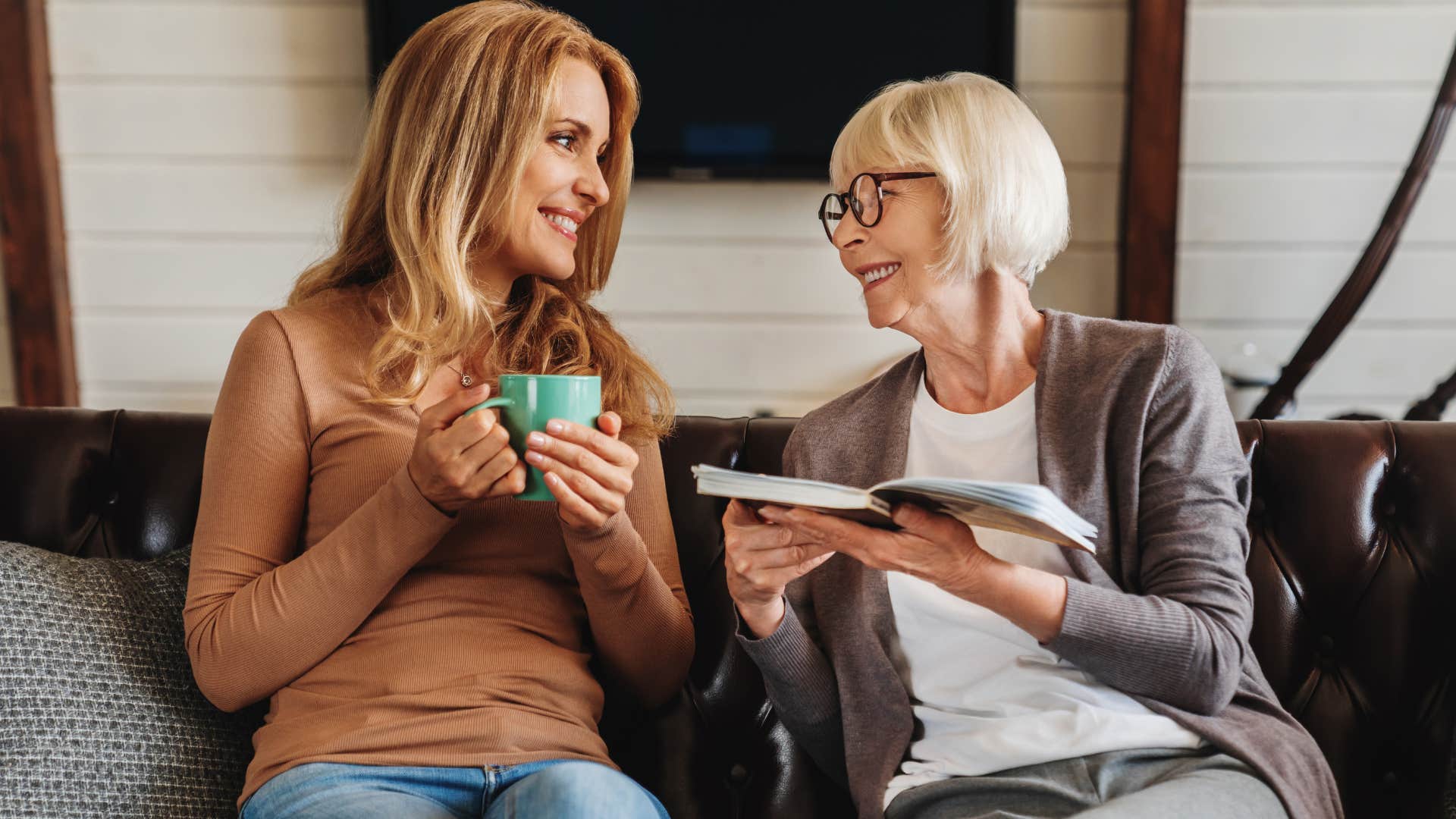 Woman and older mother talking on the couch.