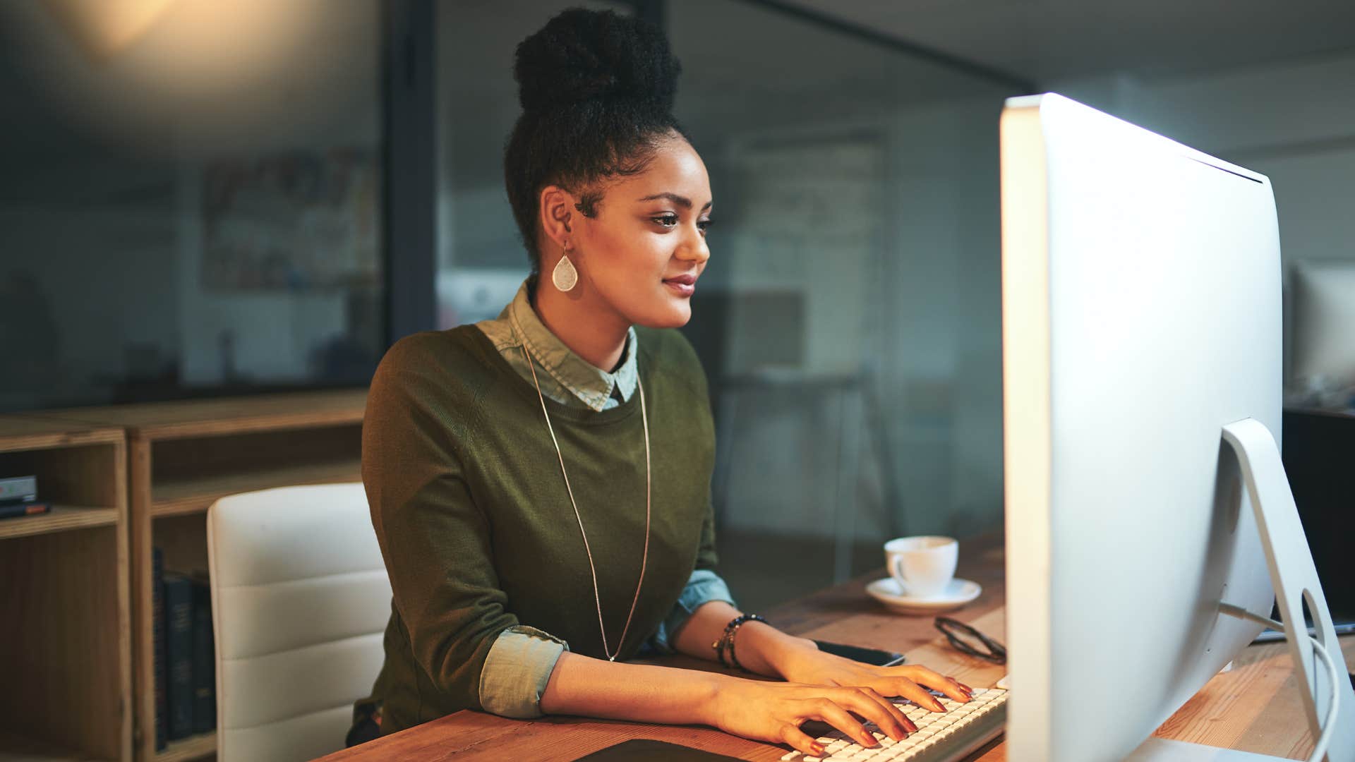 Woman smiling and typing on her computer.