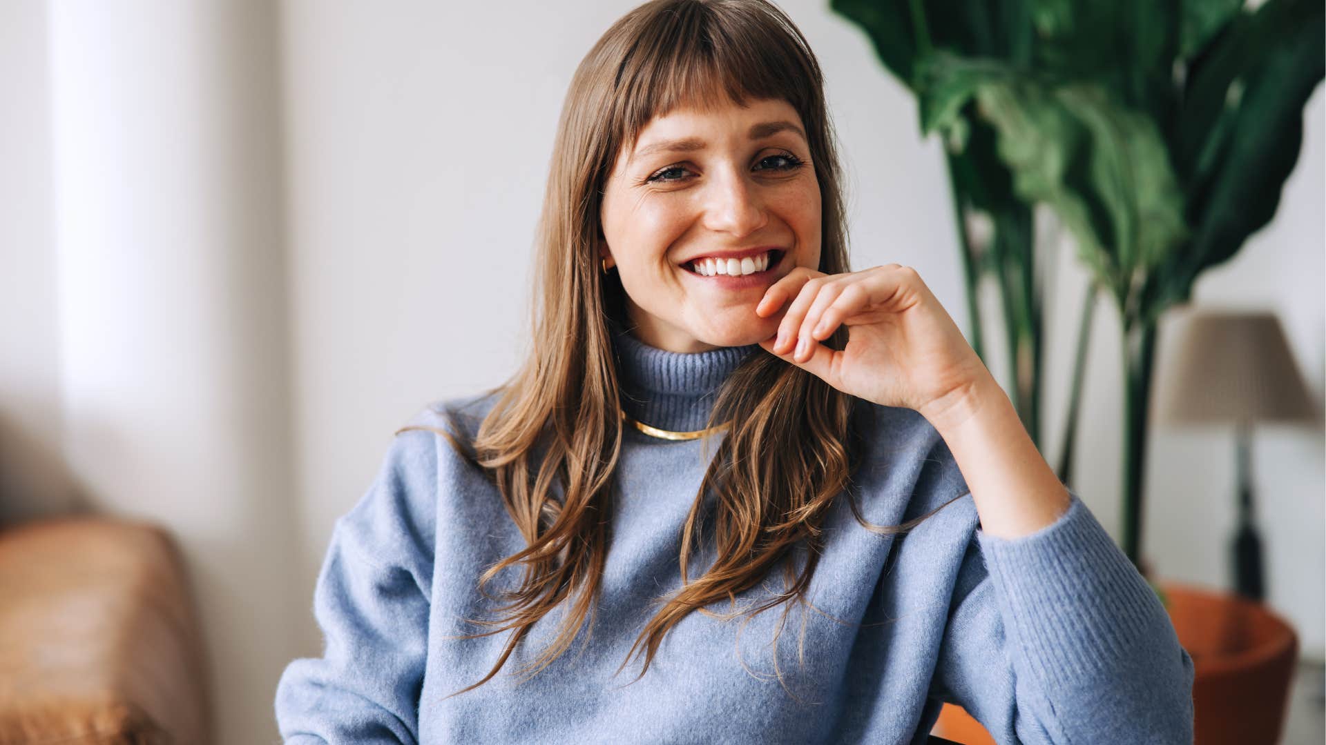 Woman smiling and sitting in a living room.