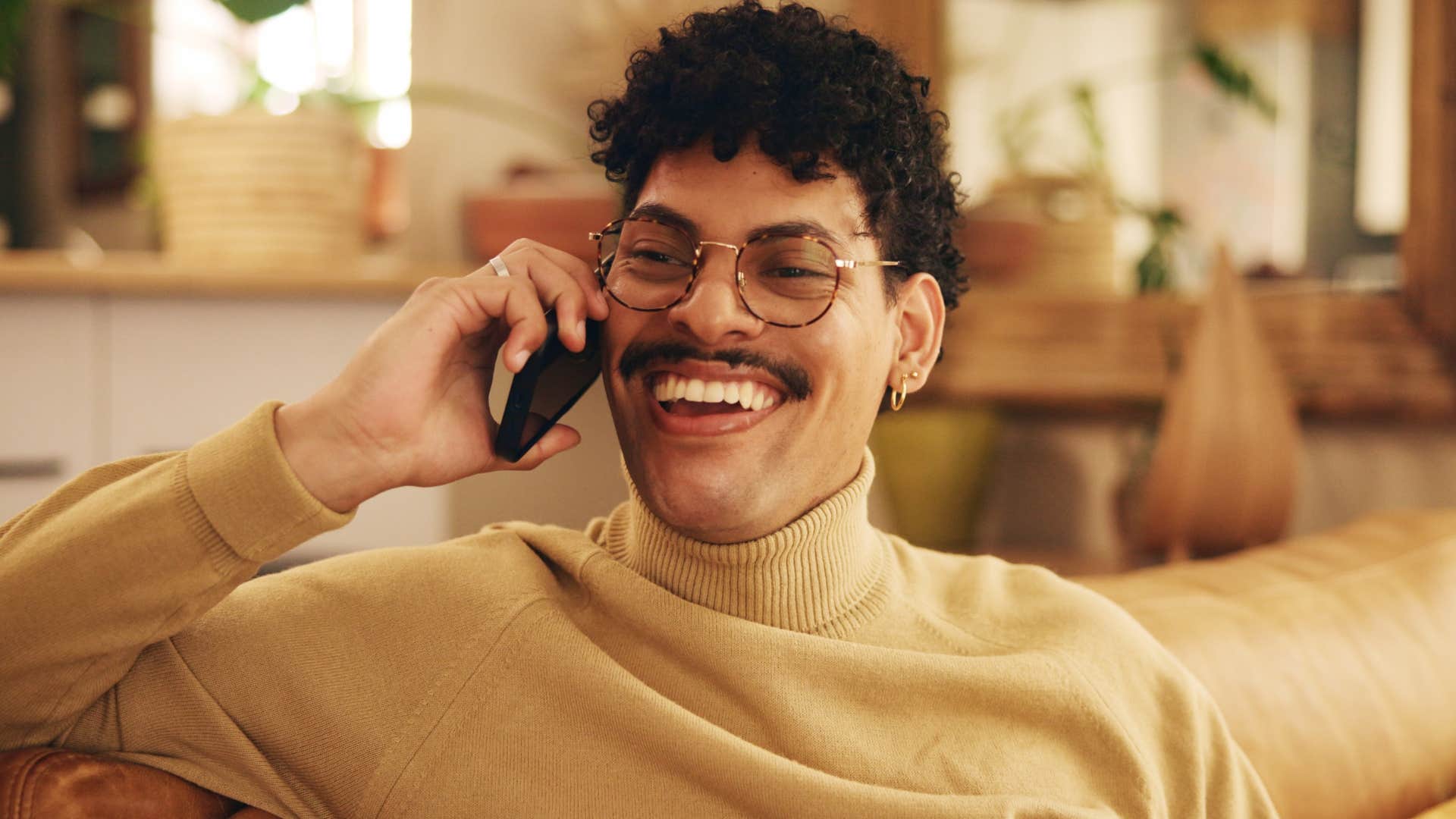 Man smiling and talking on the phone.