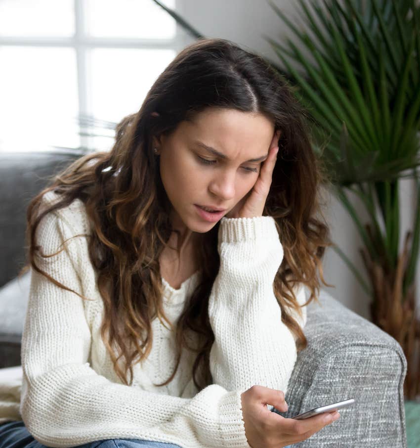 Woman is unhappy reading a text message