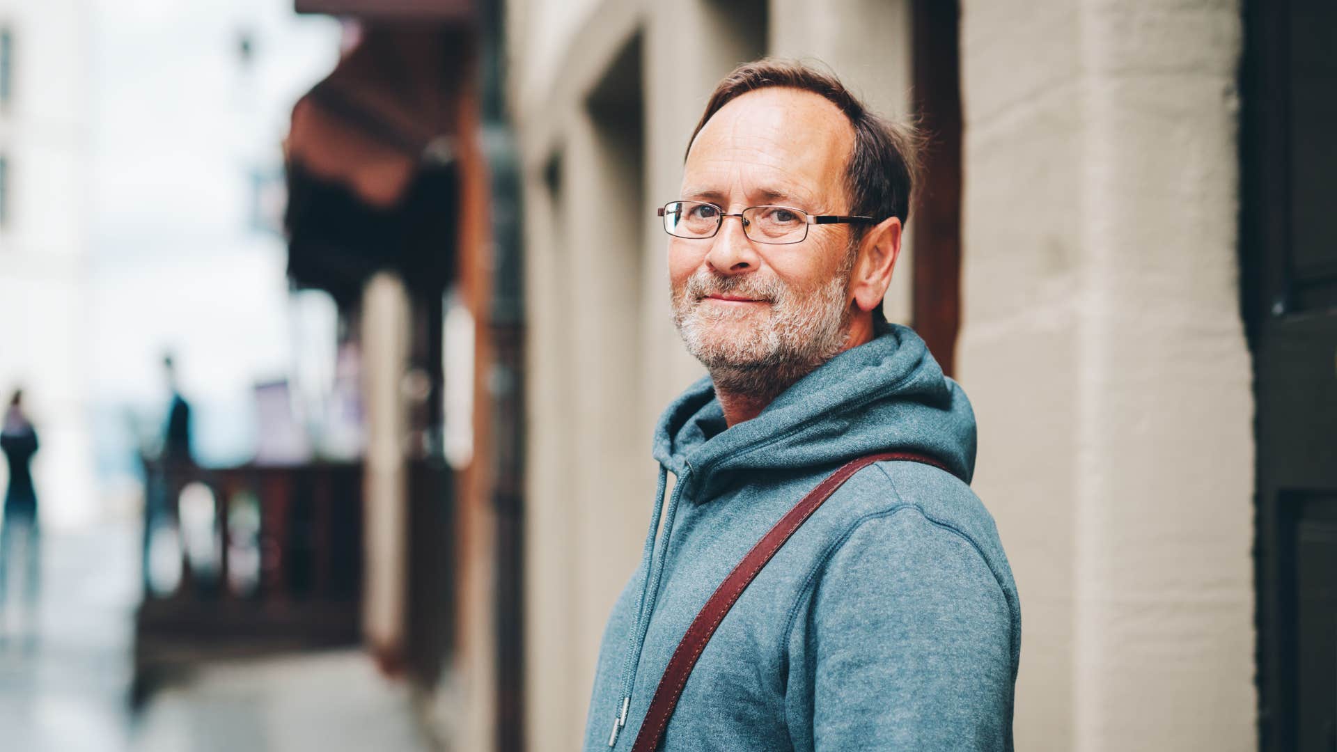 Outdoor portrait of 50 year old man wearing blue hoody and eyeglasses