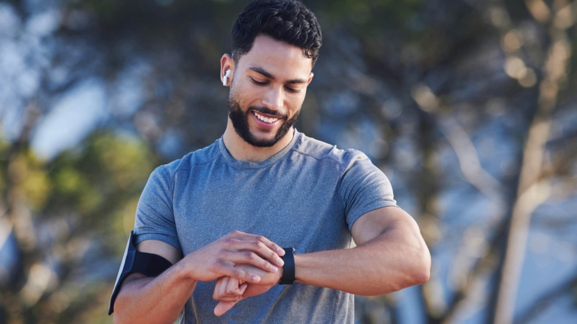 millennial man using fitness tracking device during workout 