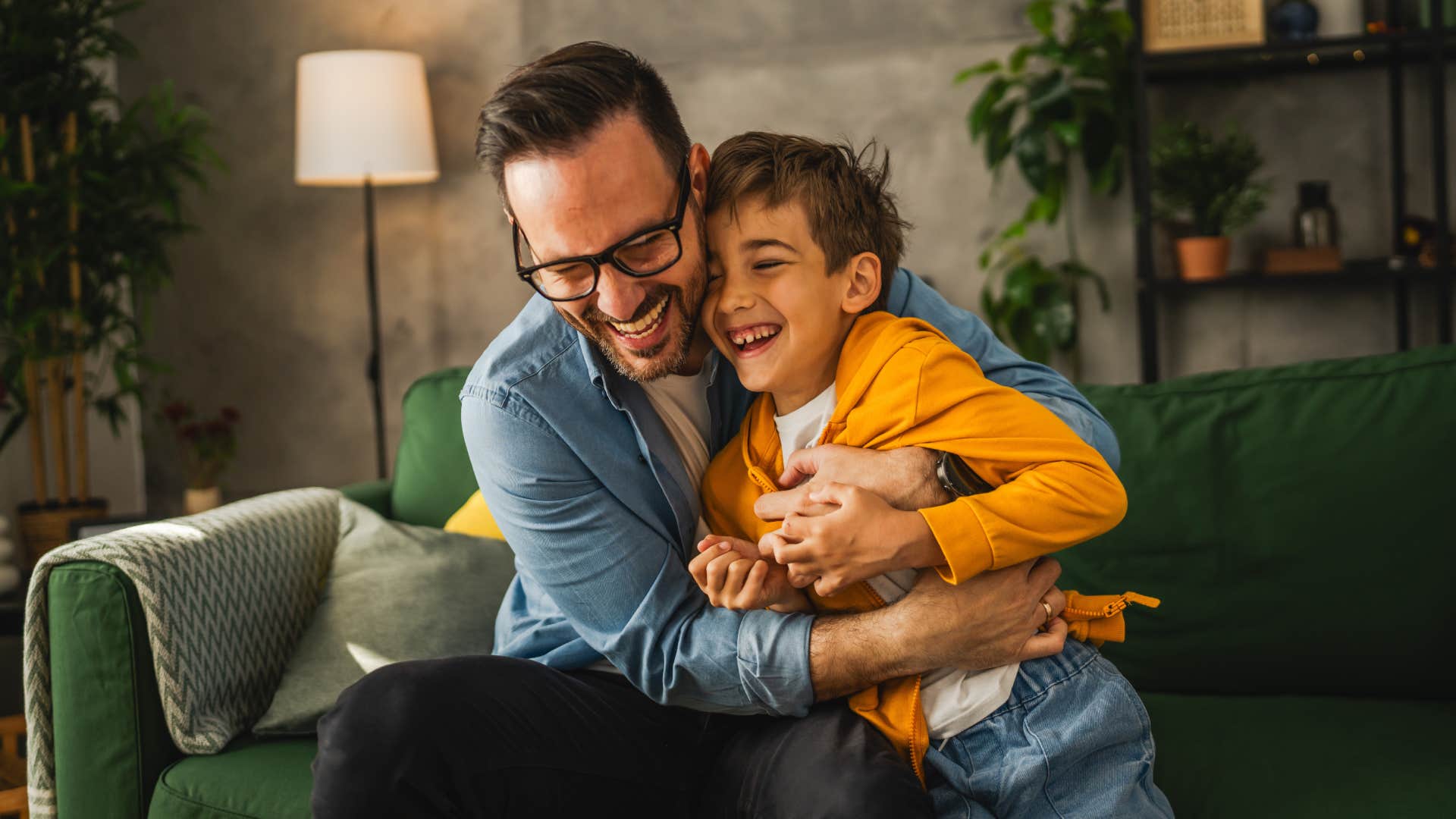 dad laughing with son on couch