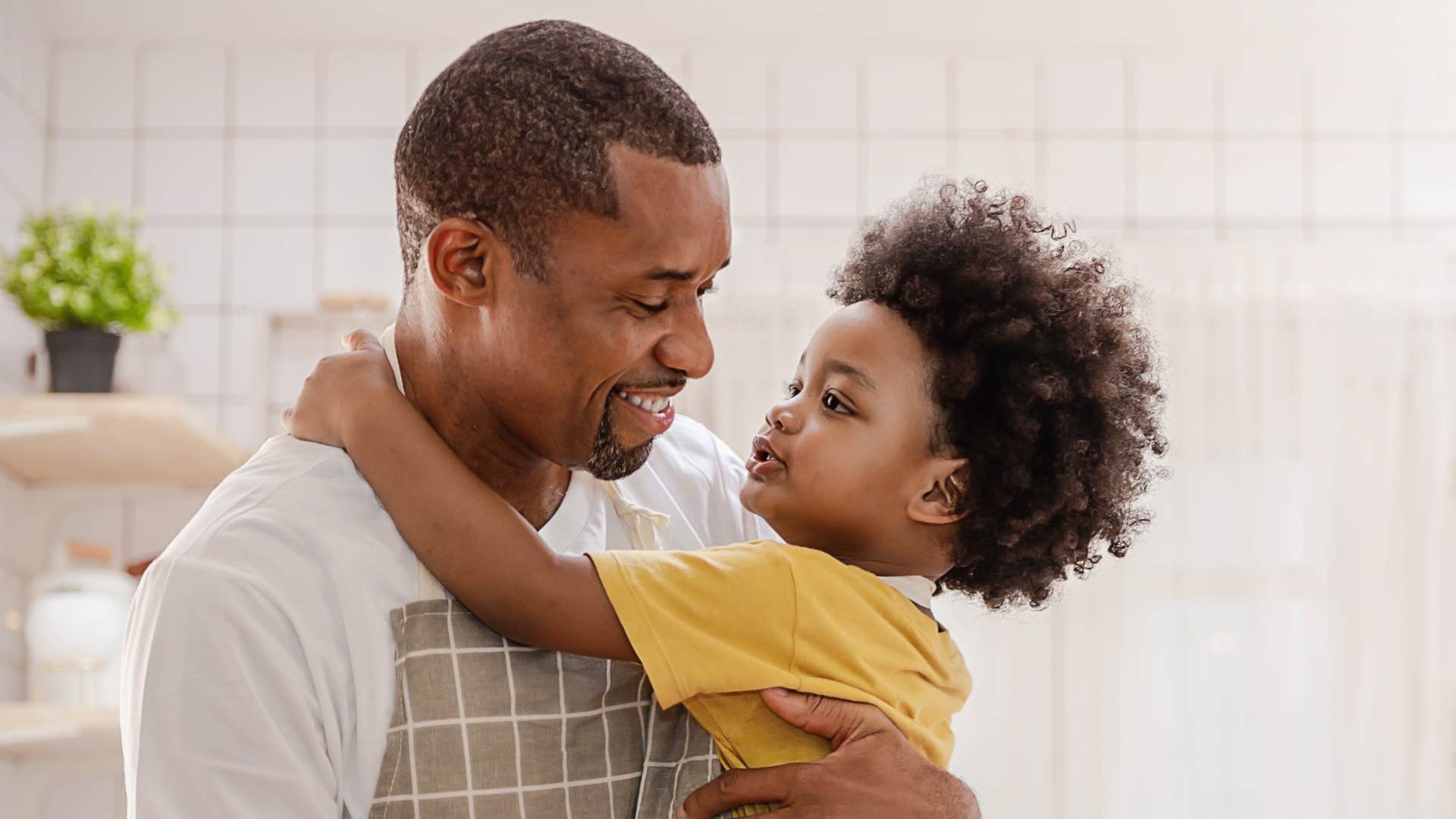 dad smiling and holding son