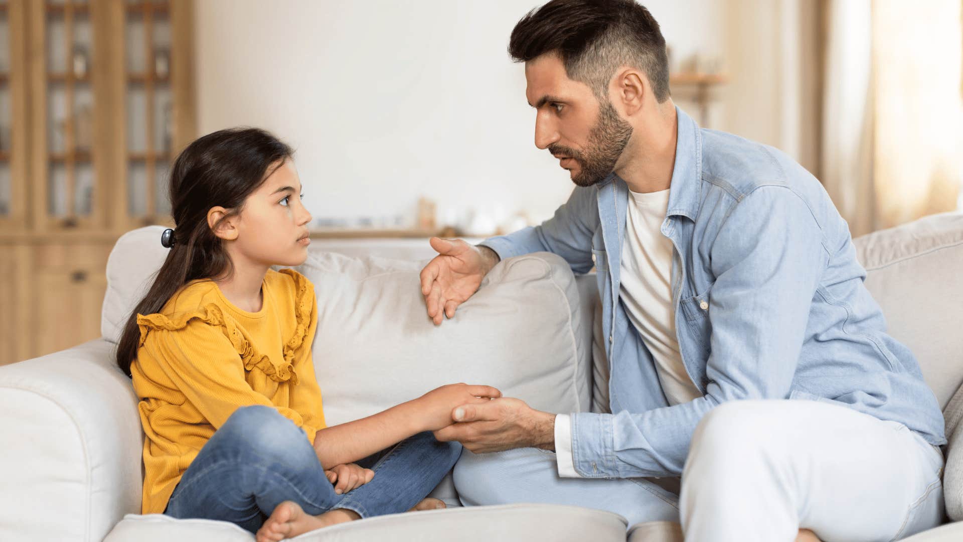 father talking to young daughter