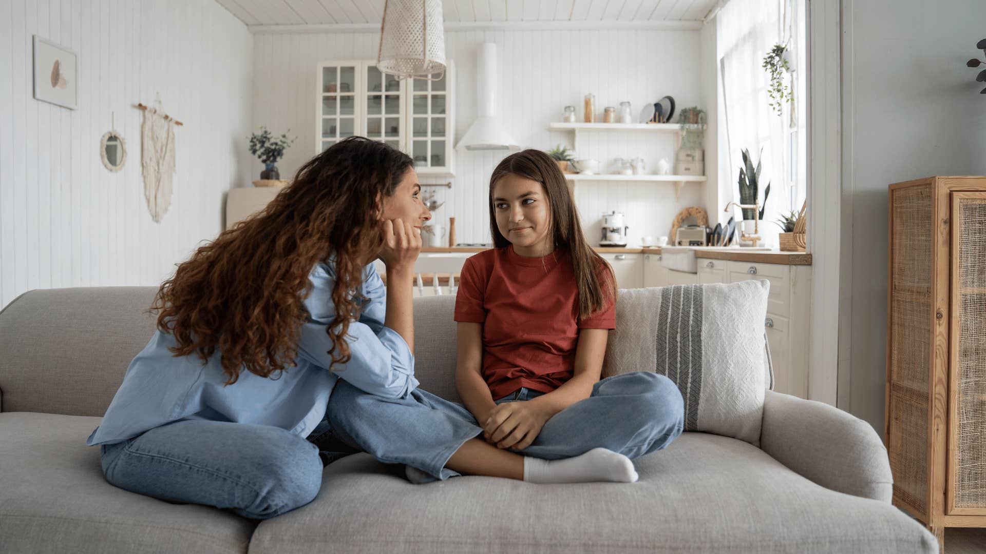 mother talking to daughter on couch