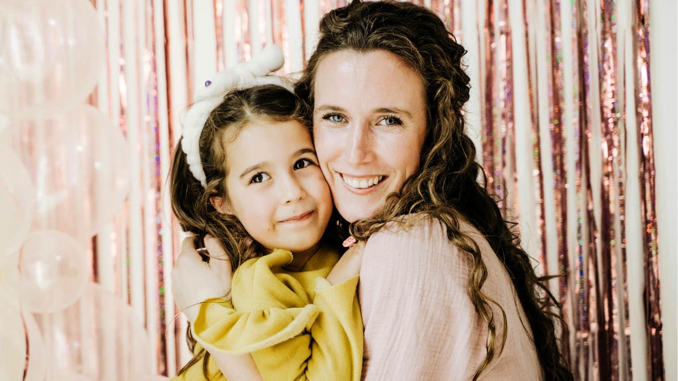 Mother holding her daughter closely.