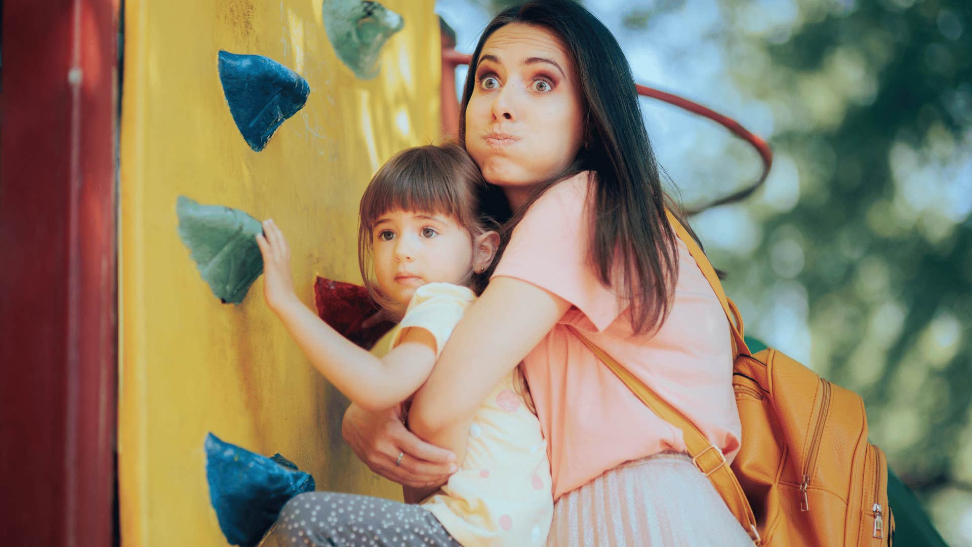 mother grabbing child off of climbing wall