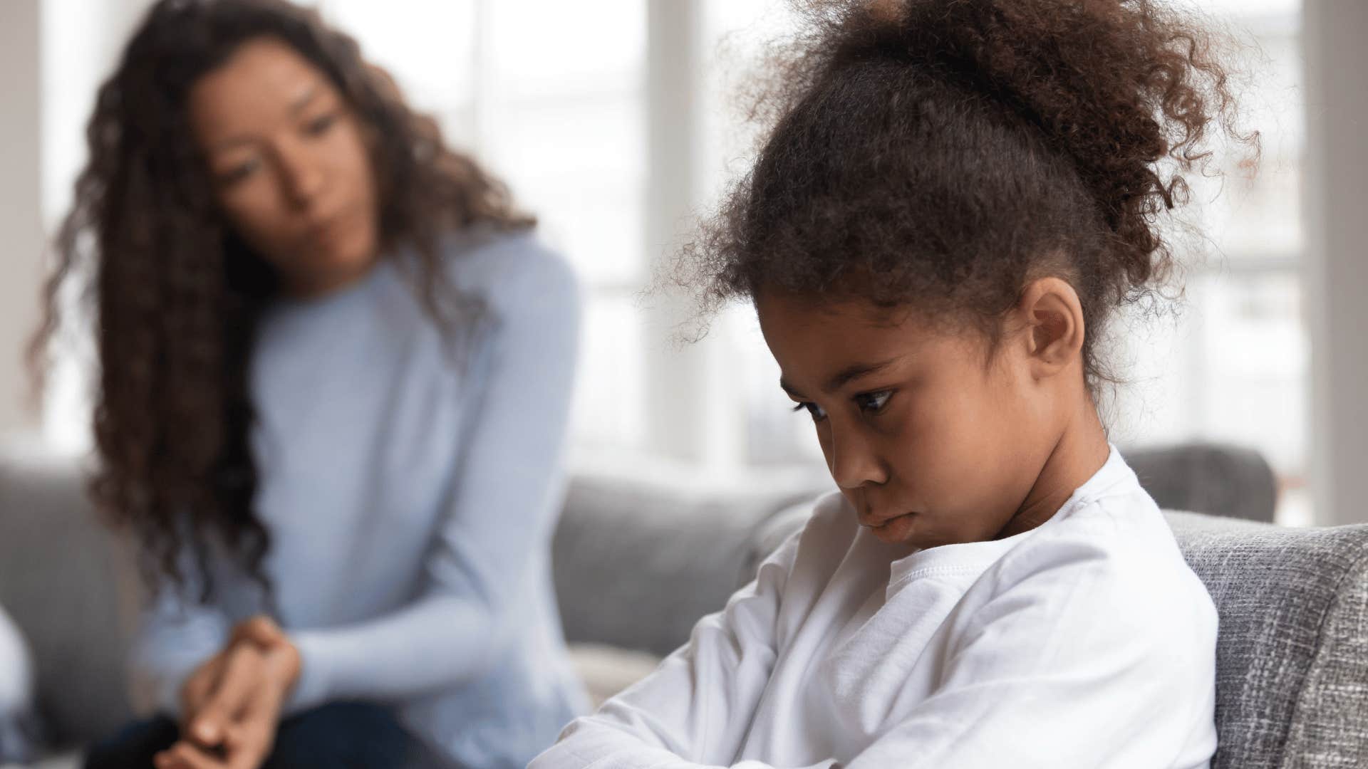 upset child with mother in abckground