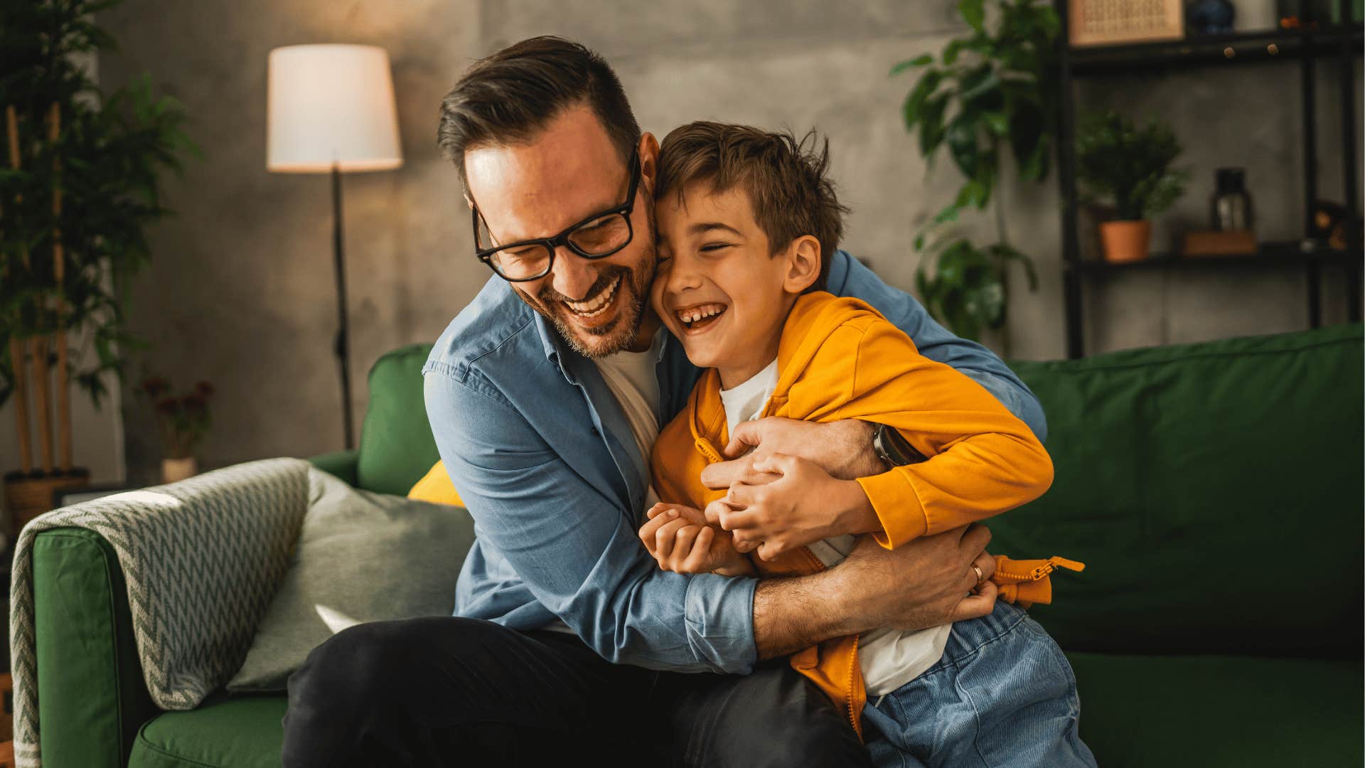 father laughing and hugging child