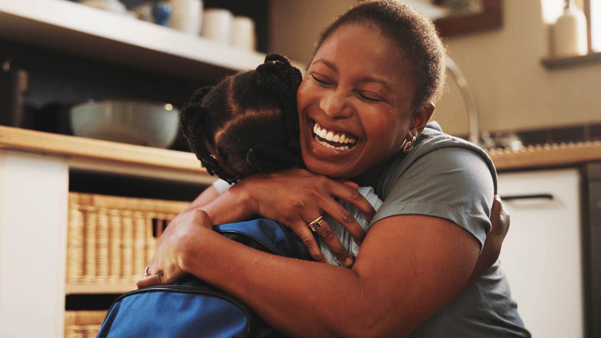 mother hugging child with backpack on