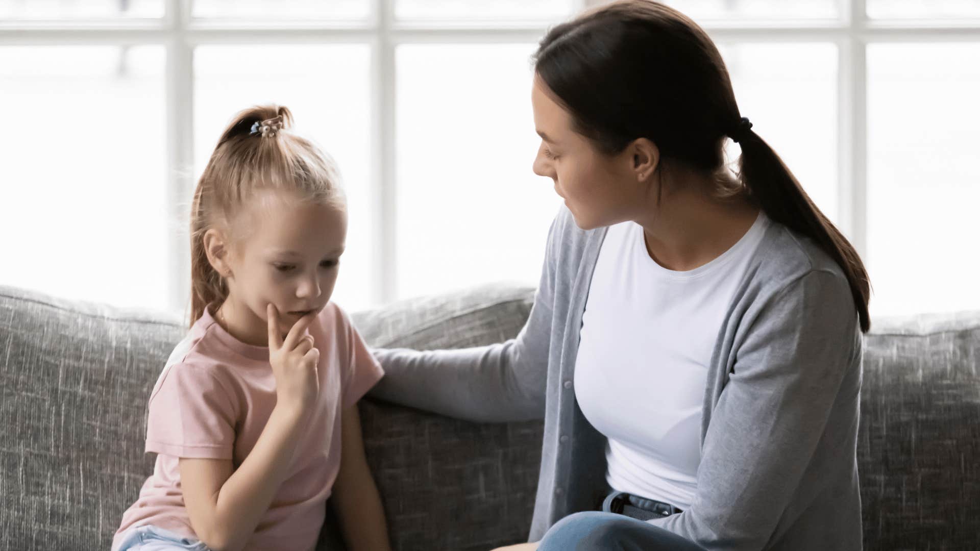 woman talking to child on couch