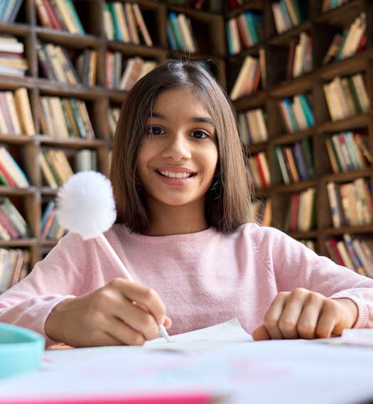 Studious child takes notes in a library