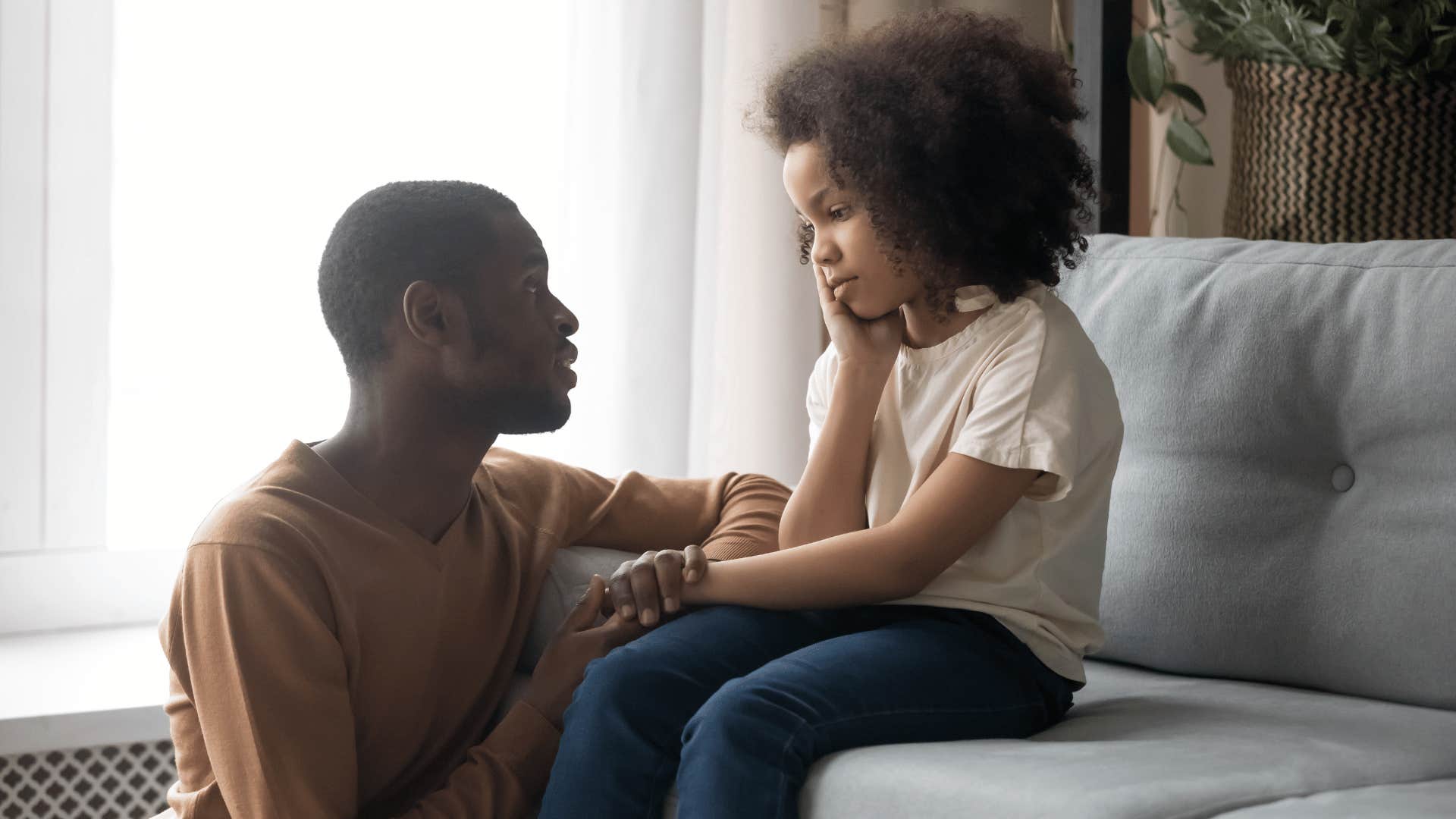 father talking to young daughter