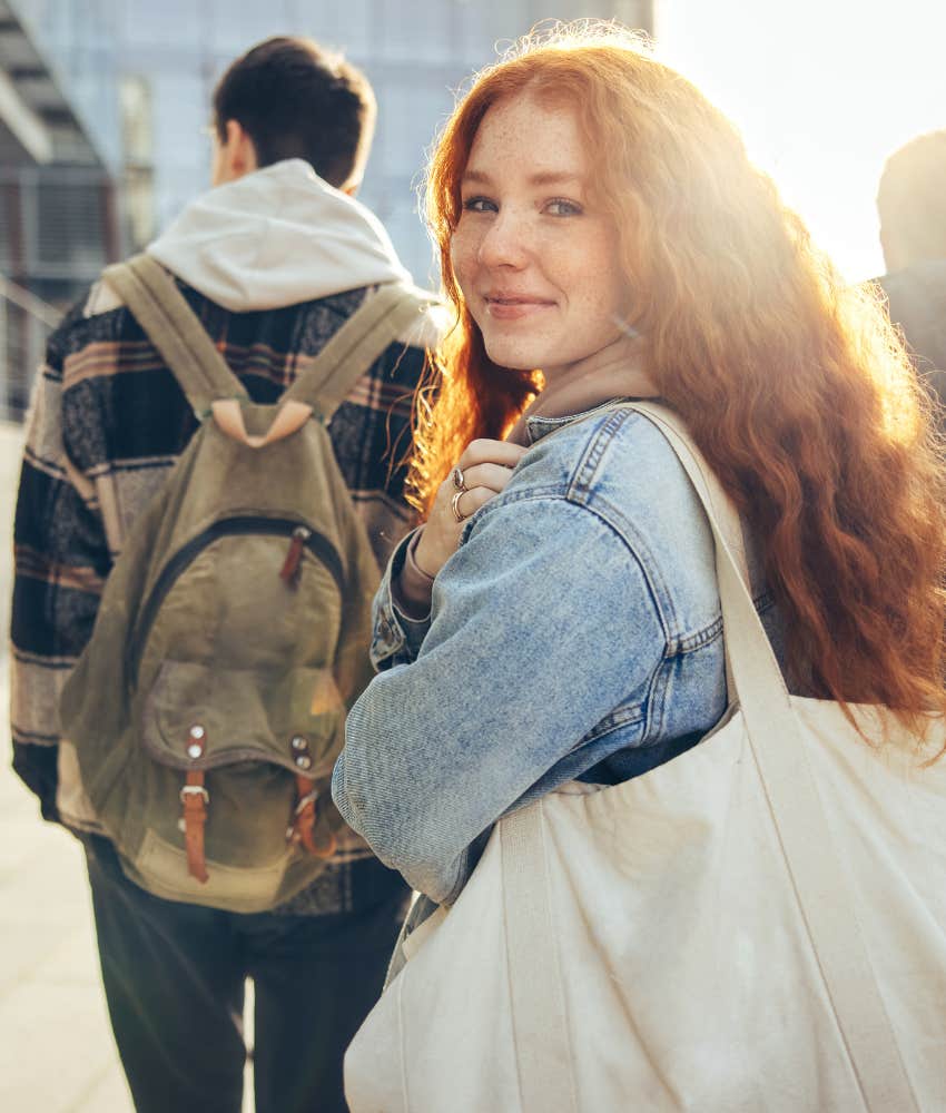 happy teen girl walking to school with peers