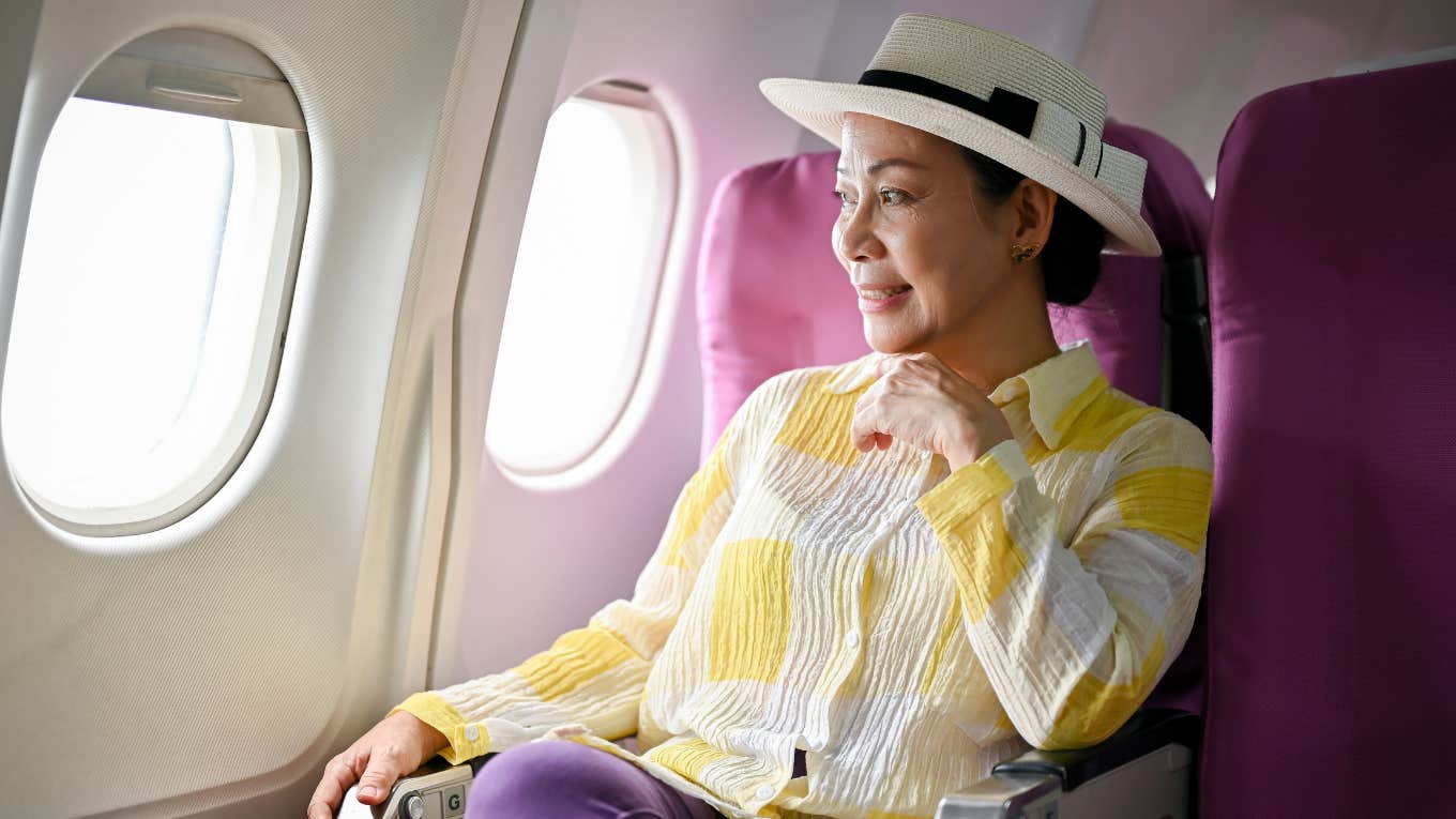 woman sitting in first class window seat on plane