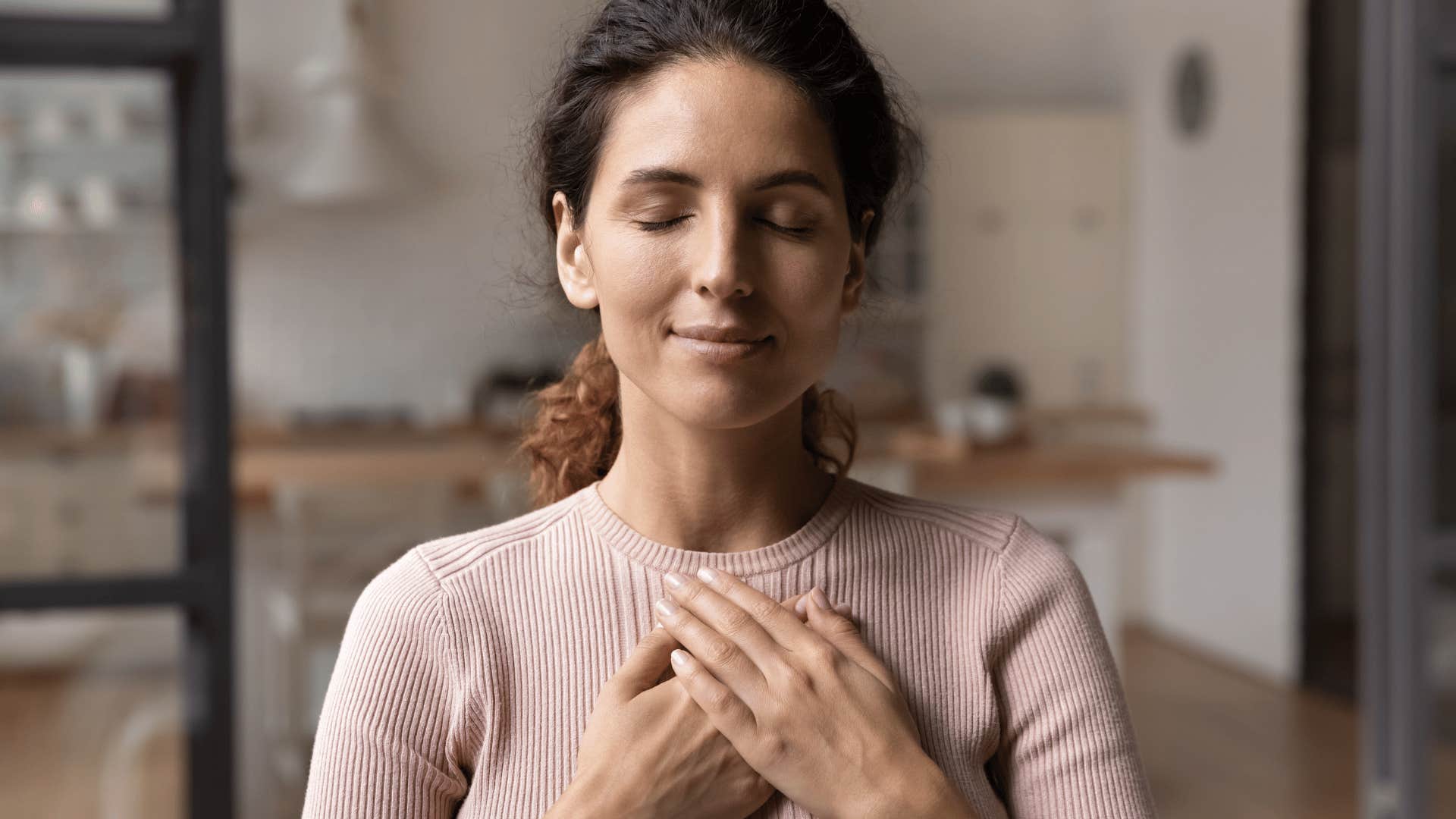 woman with her hands to her heart