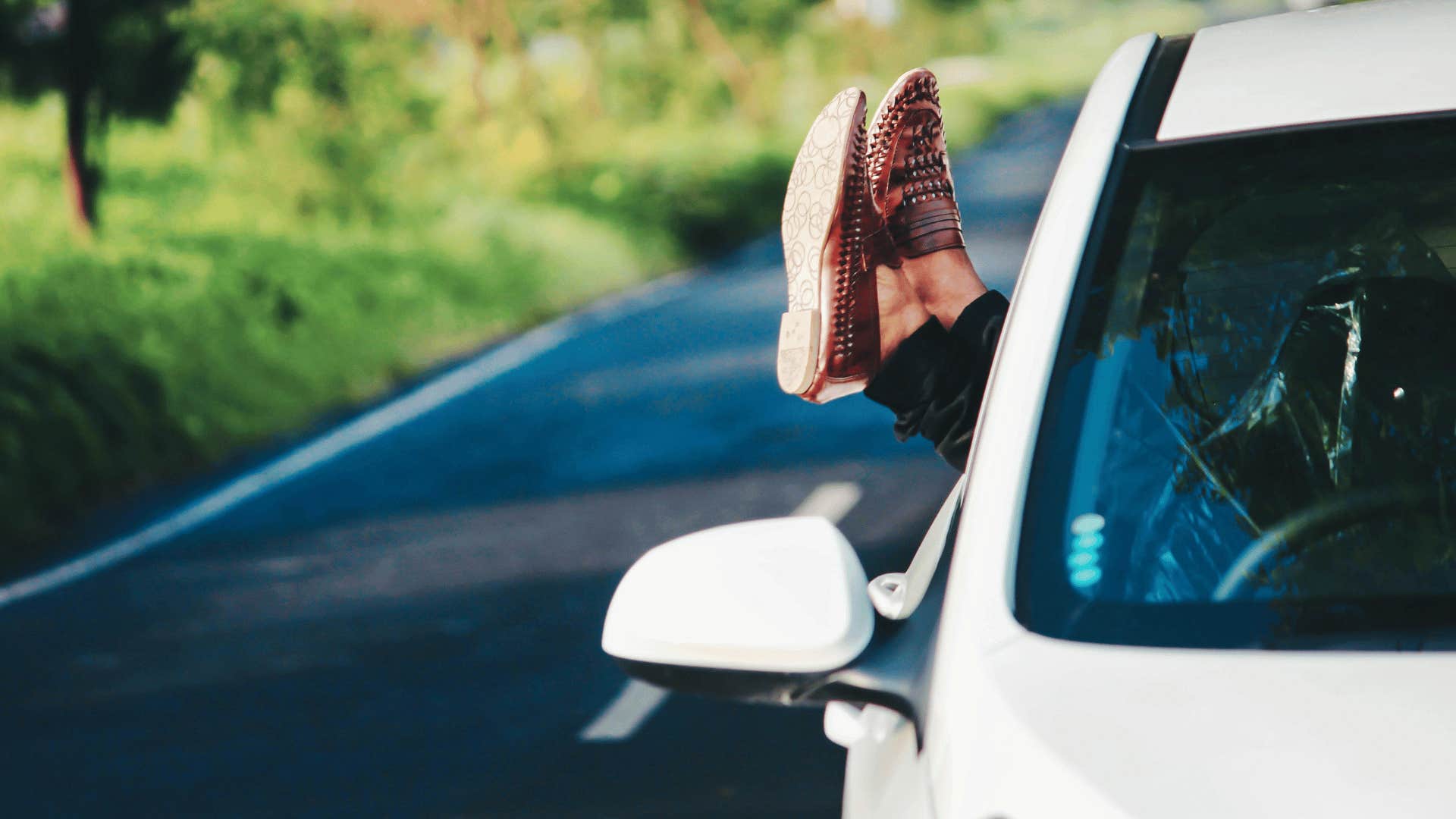 person sticking their feet out of car