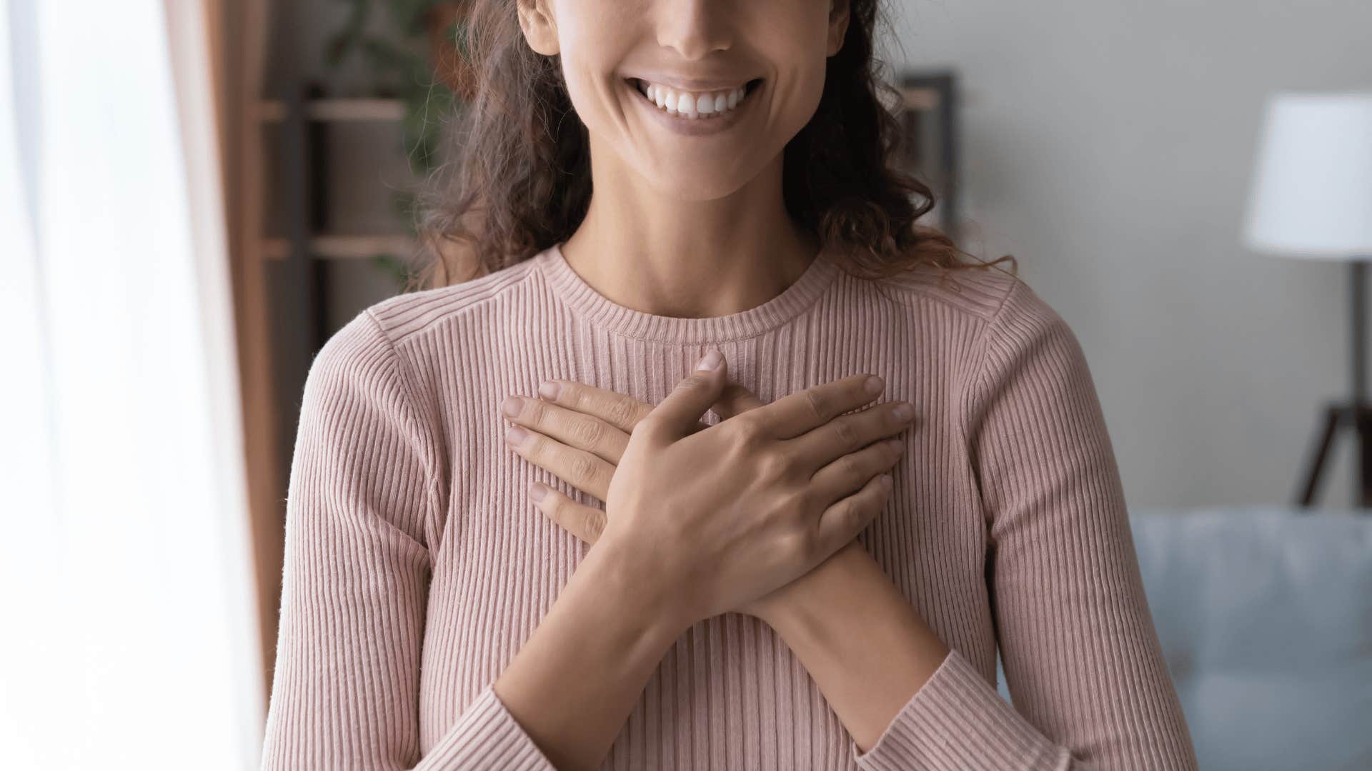 woman holding her hands to her heart