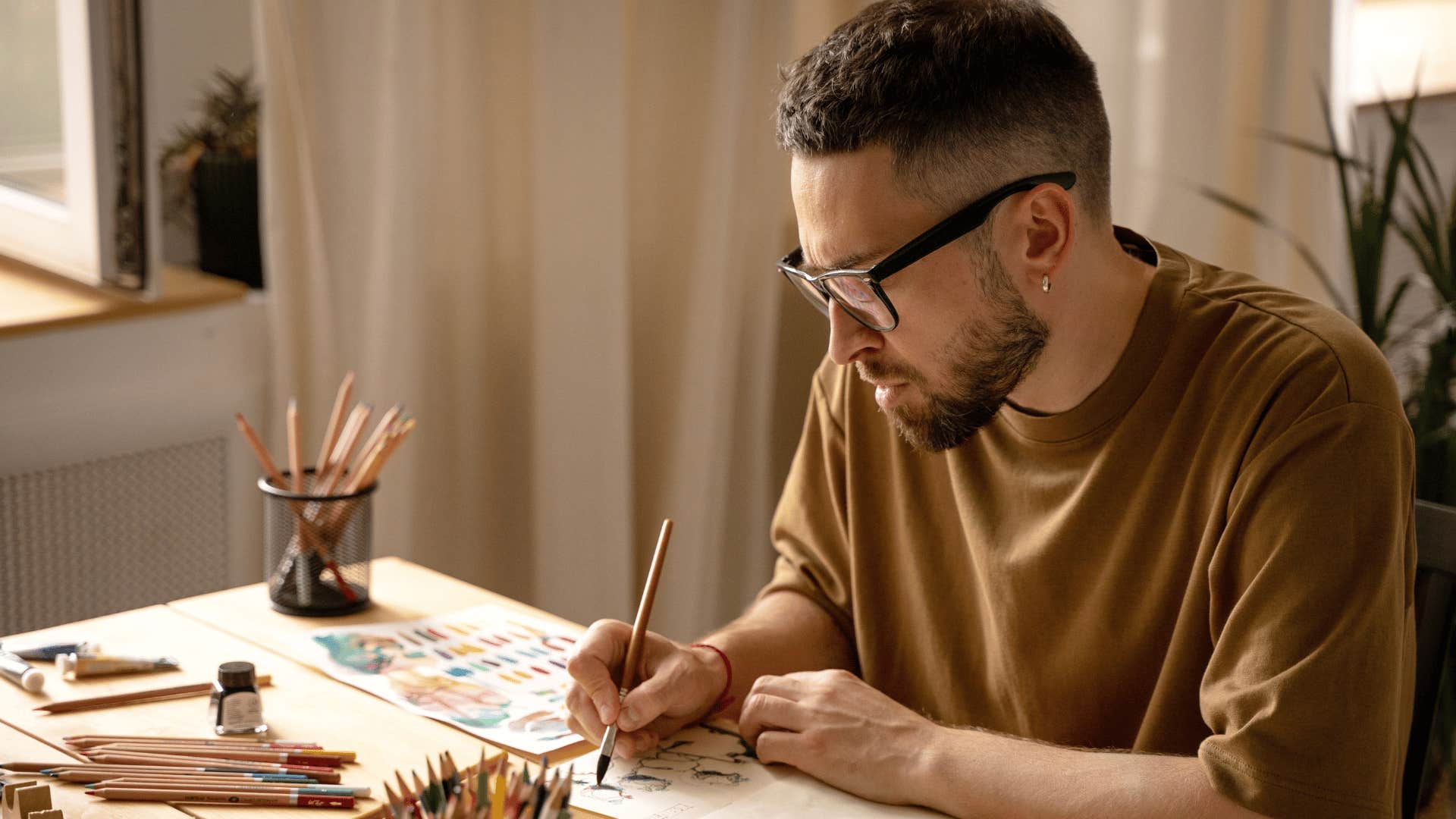 man painting in notebook