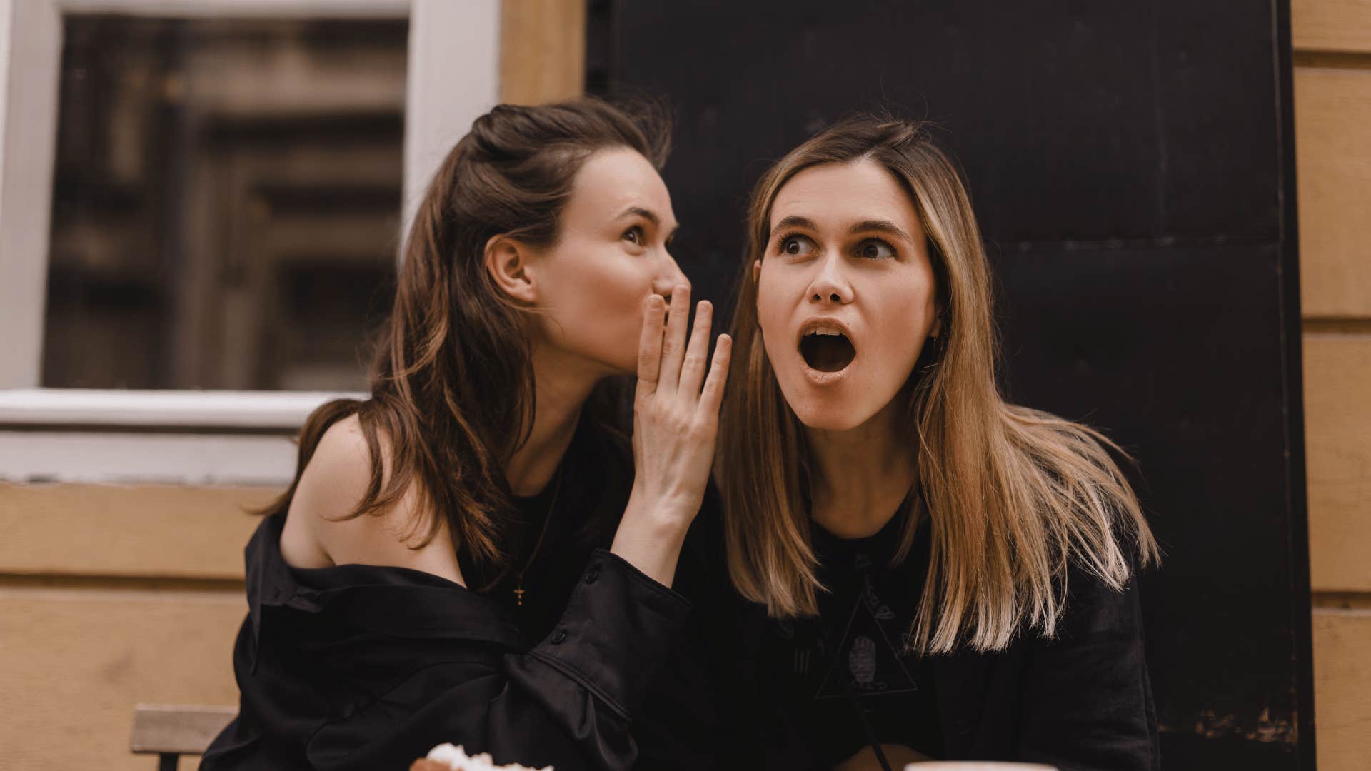 woman telling friend a secret