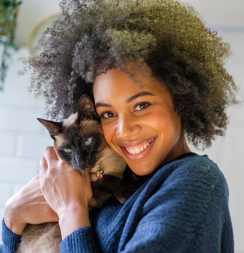 Smiling woman with her per cat