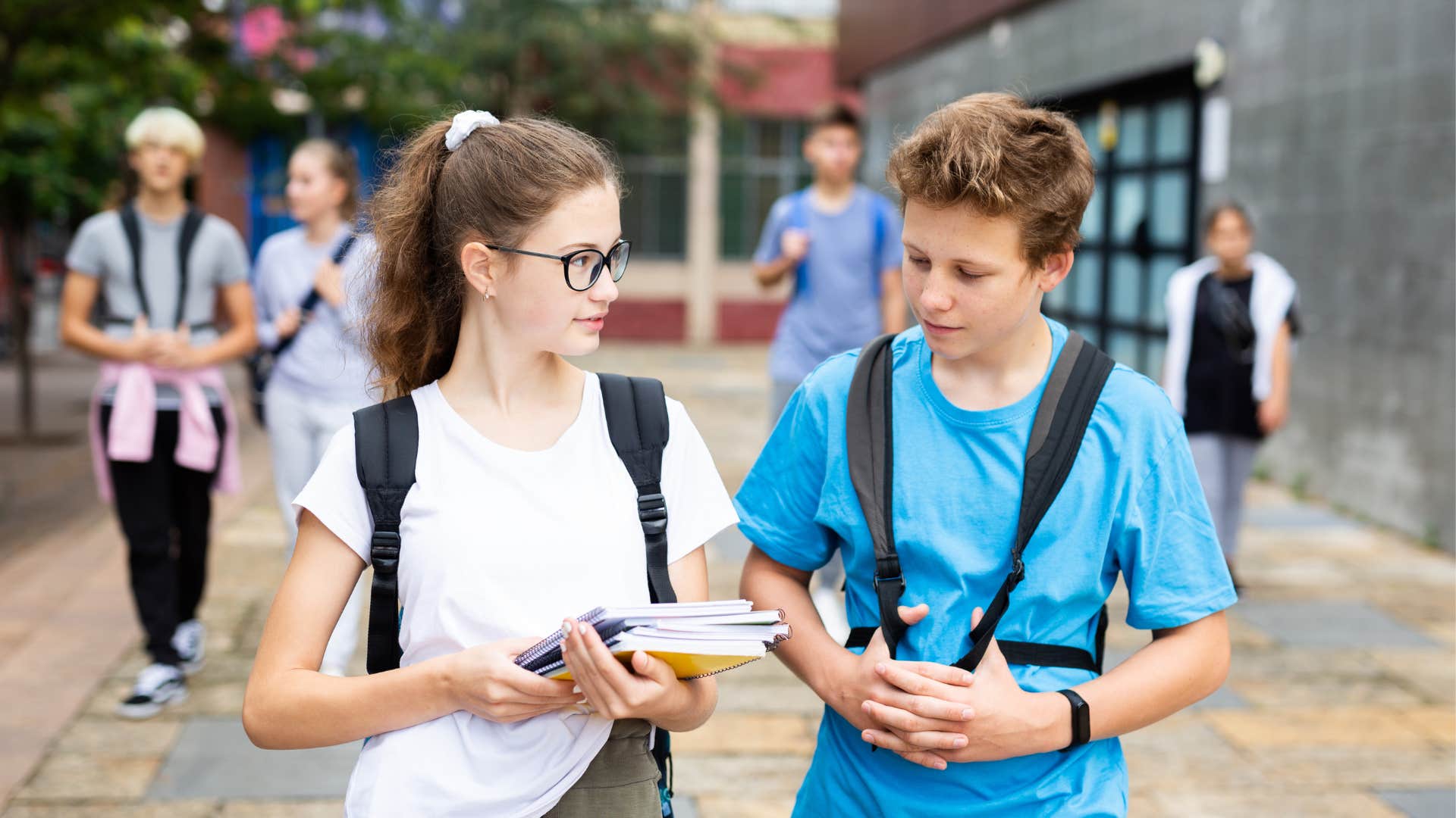 Teenage boy asks another student what her name is