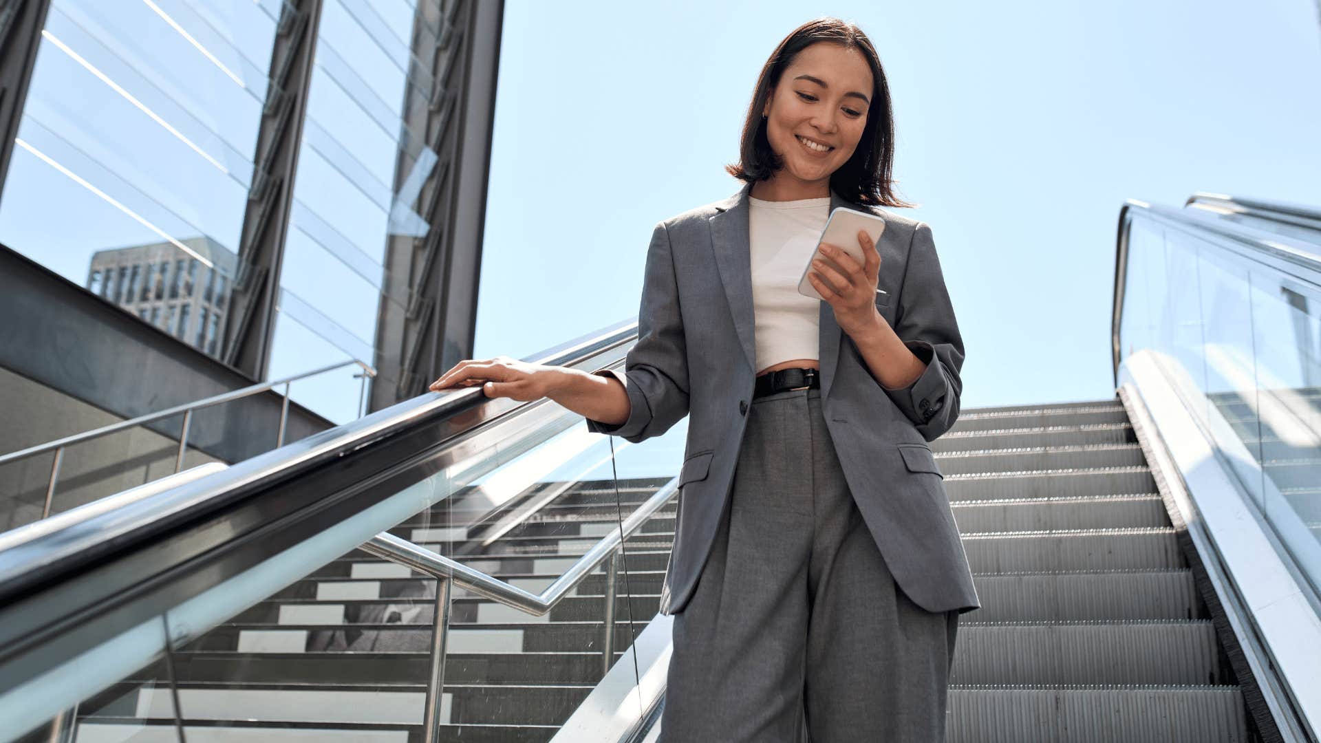 woman texting while going down the stairs 