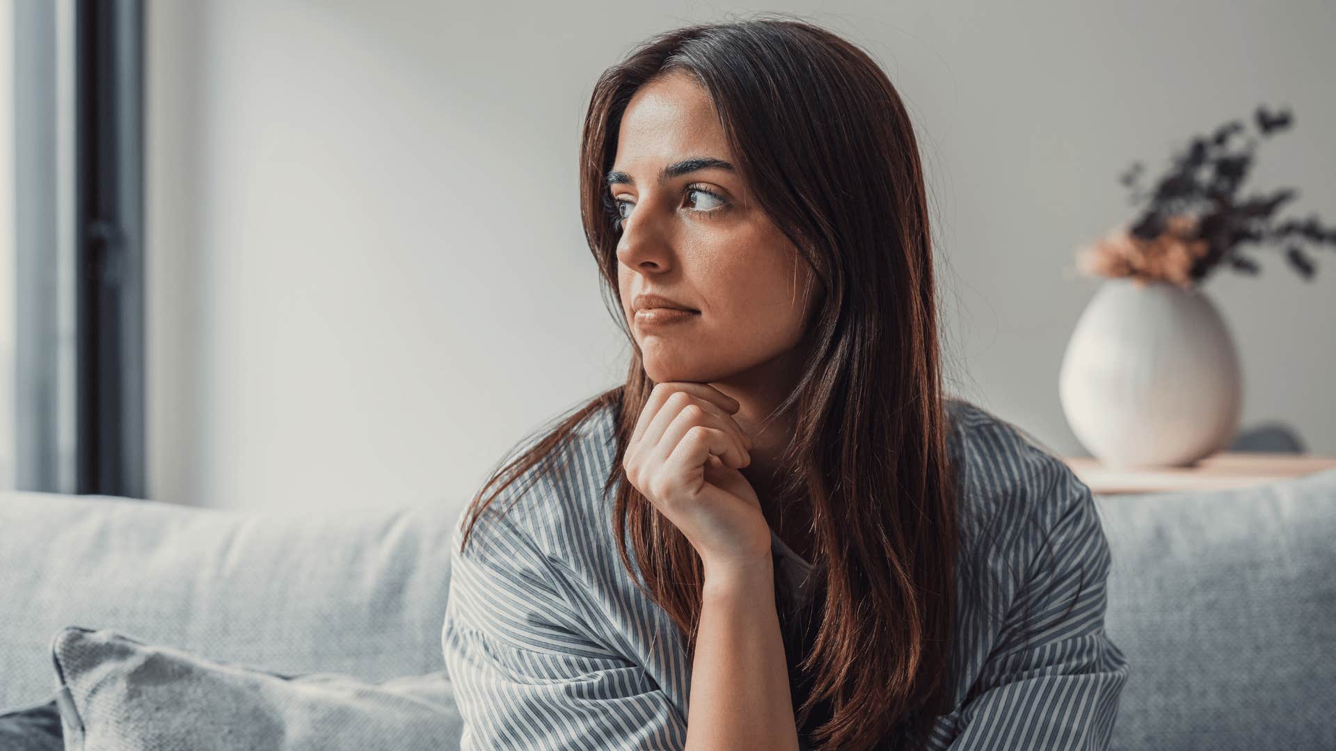 woman reflecting while sitting down on couch