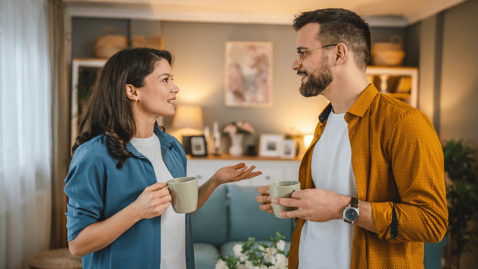 man and woman talking while drinking coffee