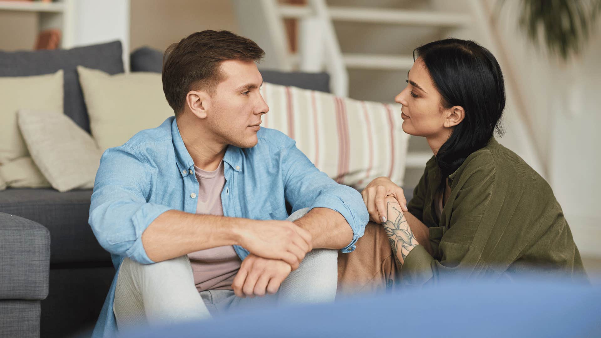 man and woman talking while sitting on the floor