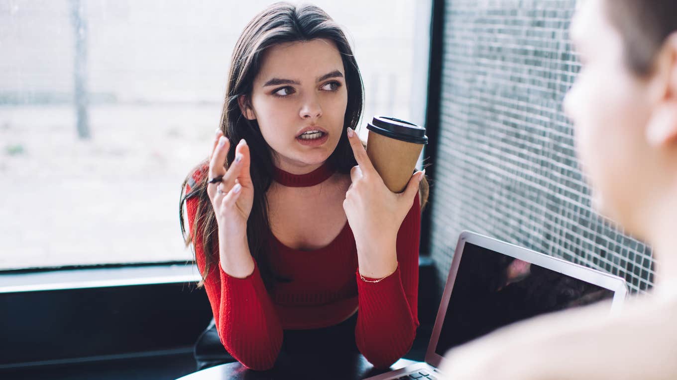 Woman in red top being irrational spouse in cafe