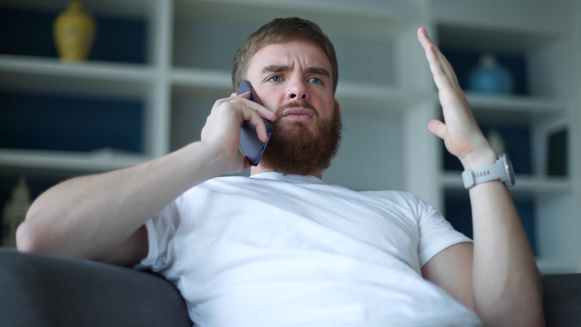 Young man looking offended talking on the phone.