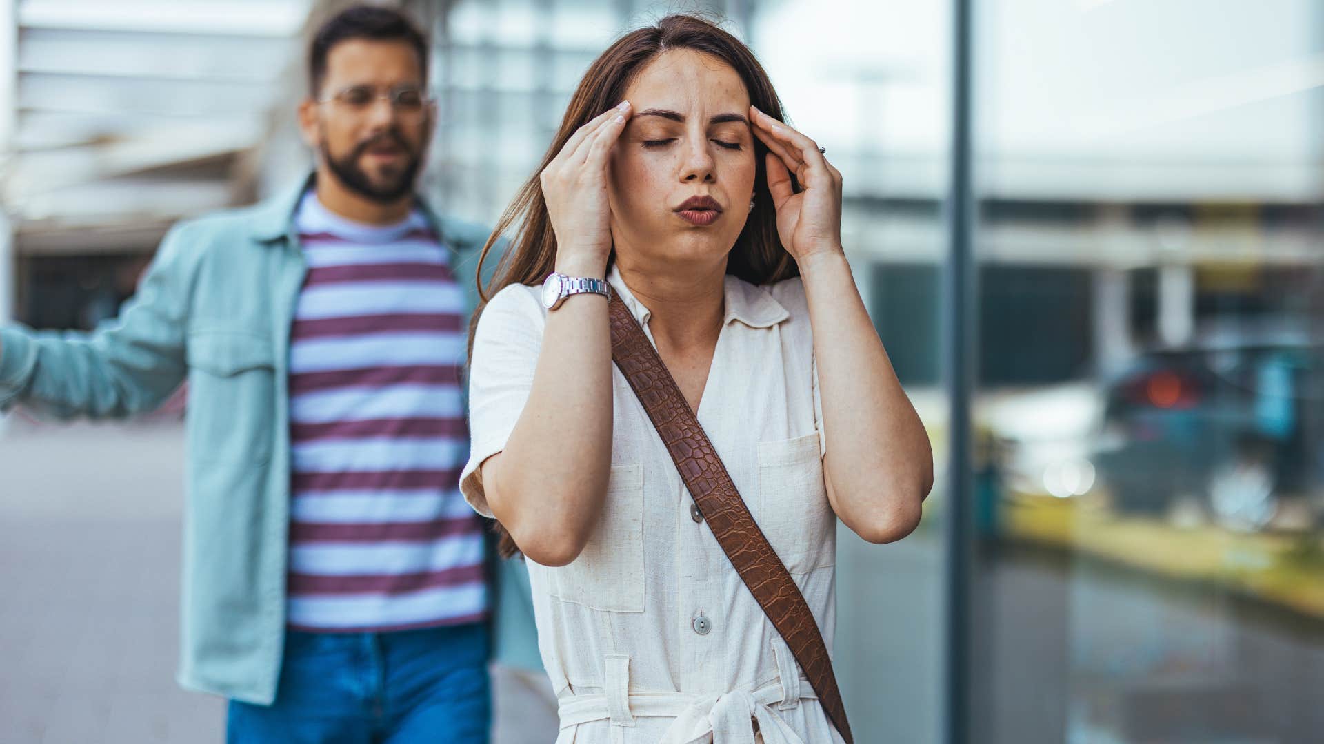 Upset woman walking away from her angry husband