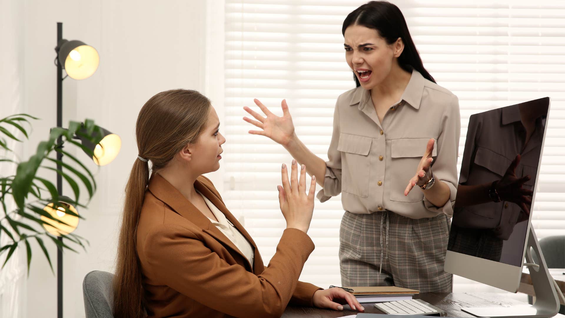 Angry woman yelling at a co-worker in an office