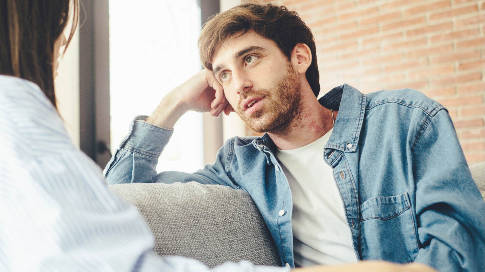 Upset man talking to his wife on the couch