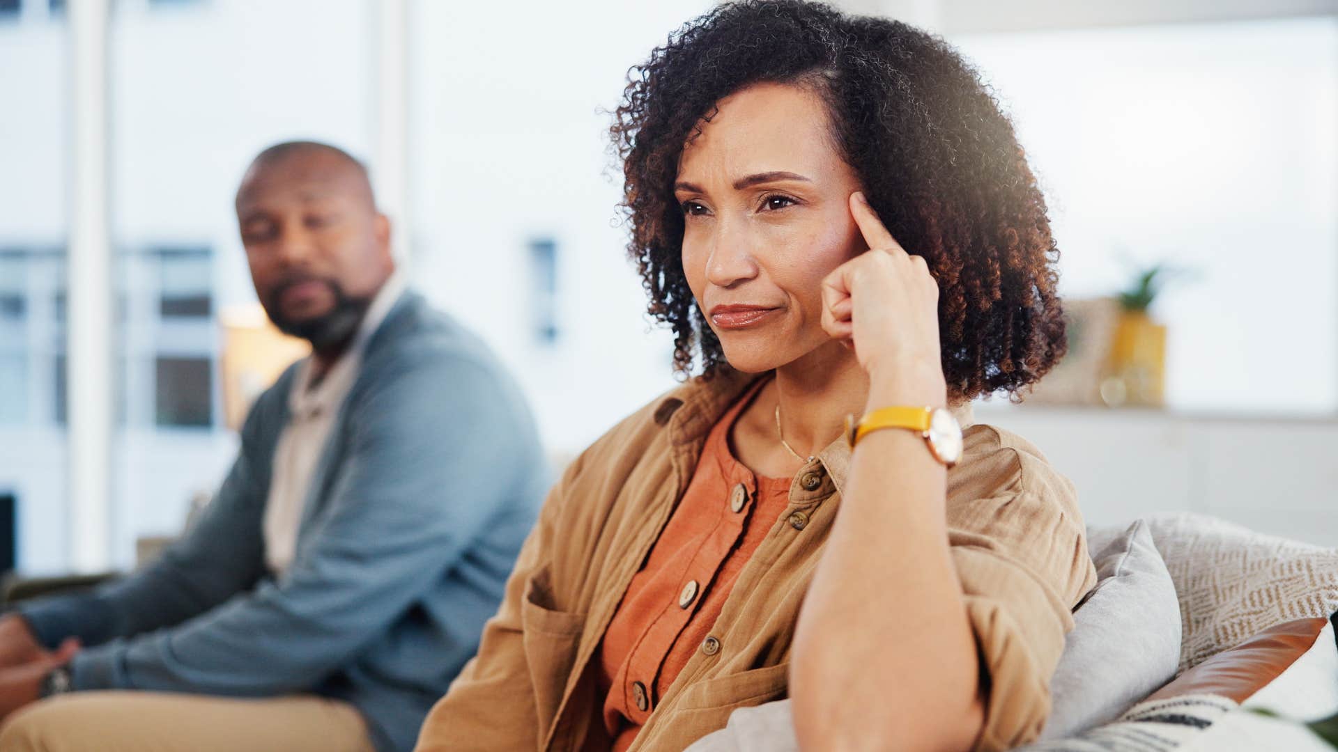 Amused woman turned away from her upset partner