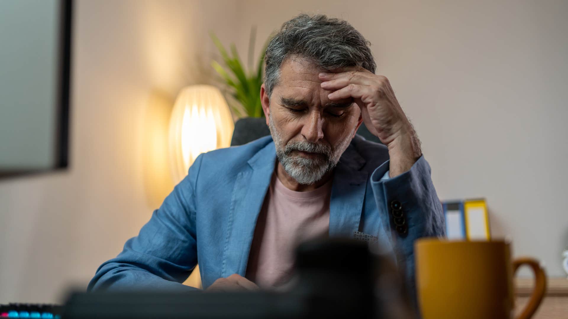 very tired man falling asleep at desk