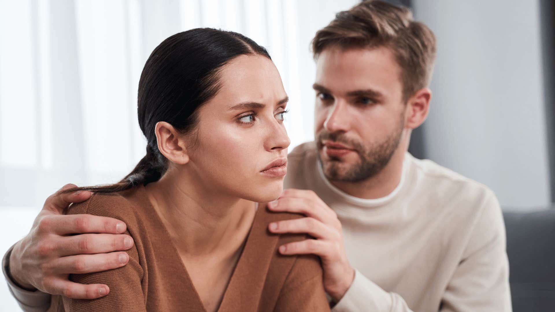 wife avoiding resolving conflict with husband rubbing her shoulders