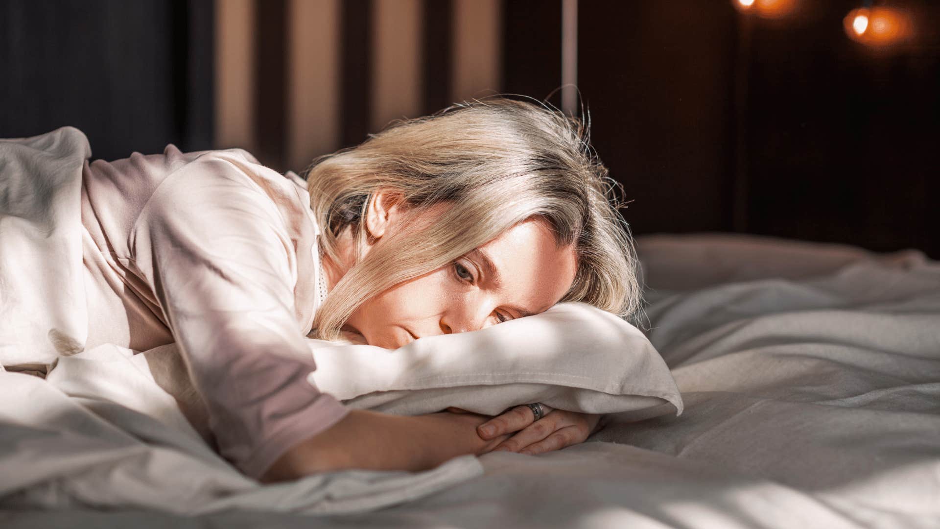 depressed woman lying in bed